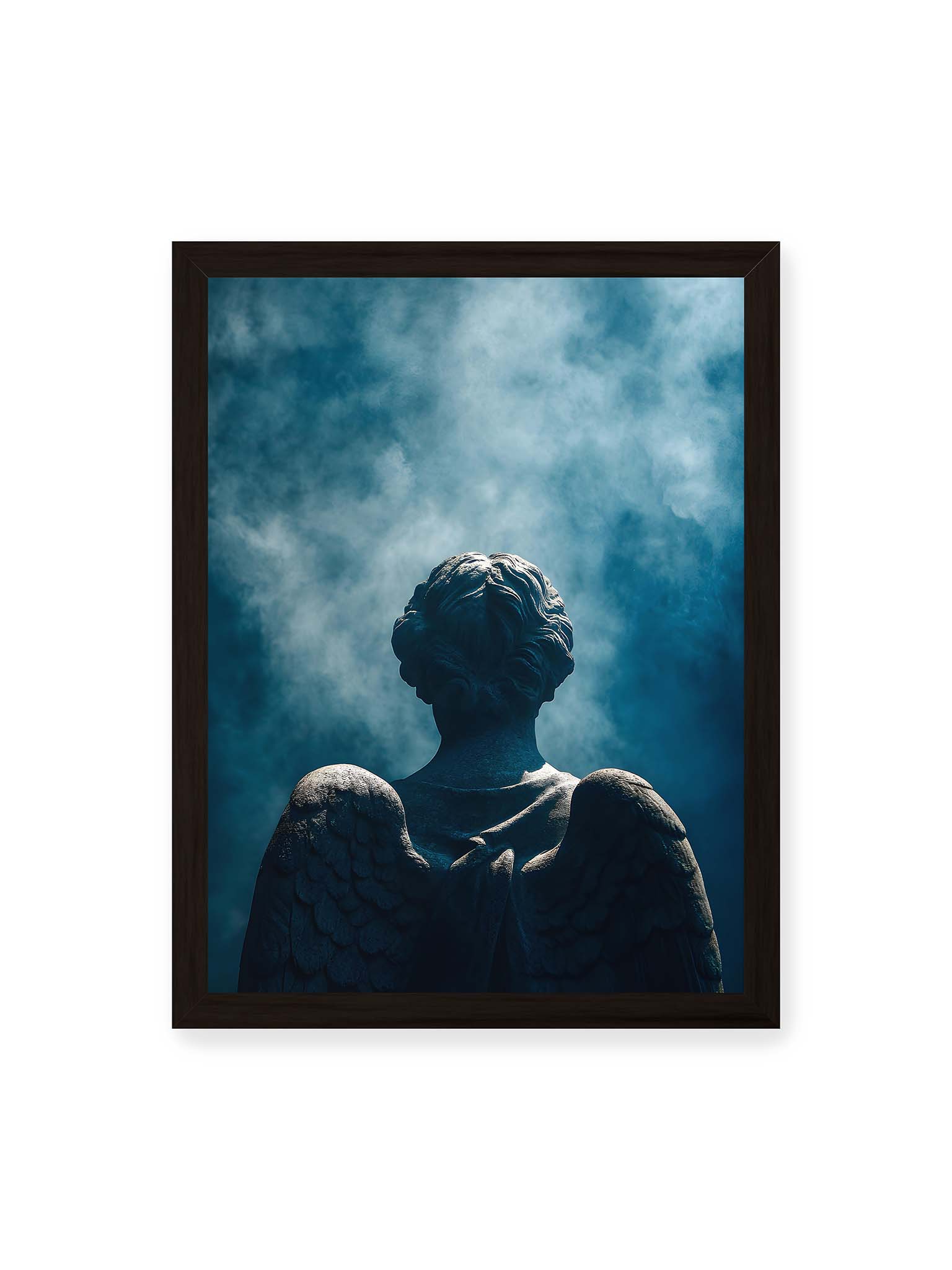 30x40 cm, schwarzer Rahmen – Rückansicht einer steinernen Engelsfigur mit ausgebreiteten Flügeln vor blauem Himmel und aufsteigendem Nebel.