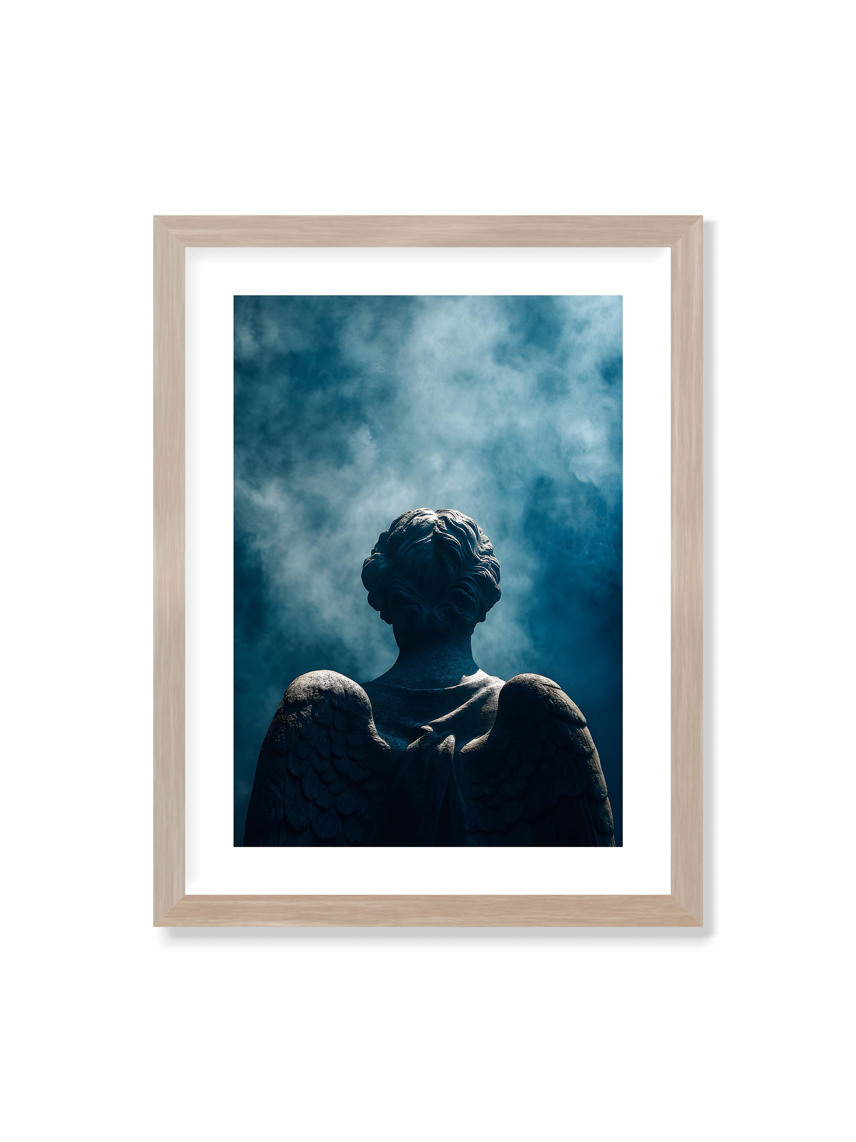 30x40 cm mit weißem Galerie-Rand im Eichenrahmen – Steinerne Engelsfigur von hinten mit ausgebreiteten Flügeln vor blauem, nebligem Himmel.