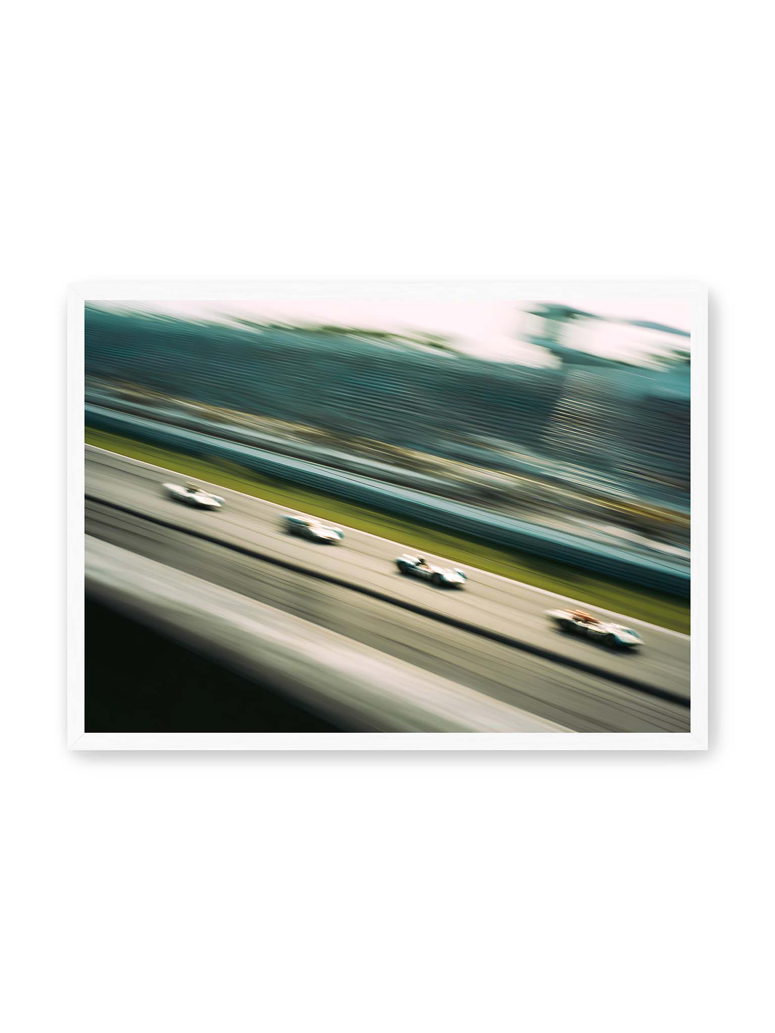 50x70 cm, weißer Rahmen – Mehrere Rennwagen in starker Bewegungsunschärfe auf einer Rennstrecke, diagonal ausgerichtet.