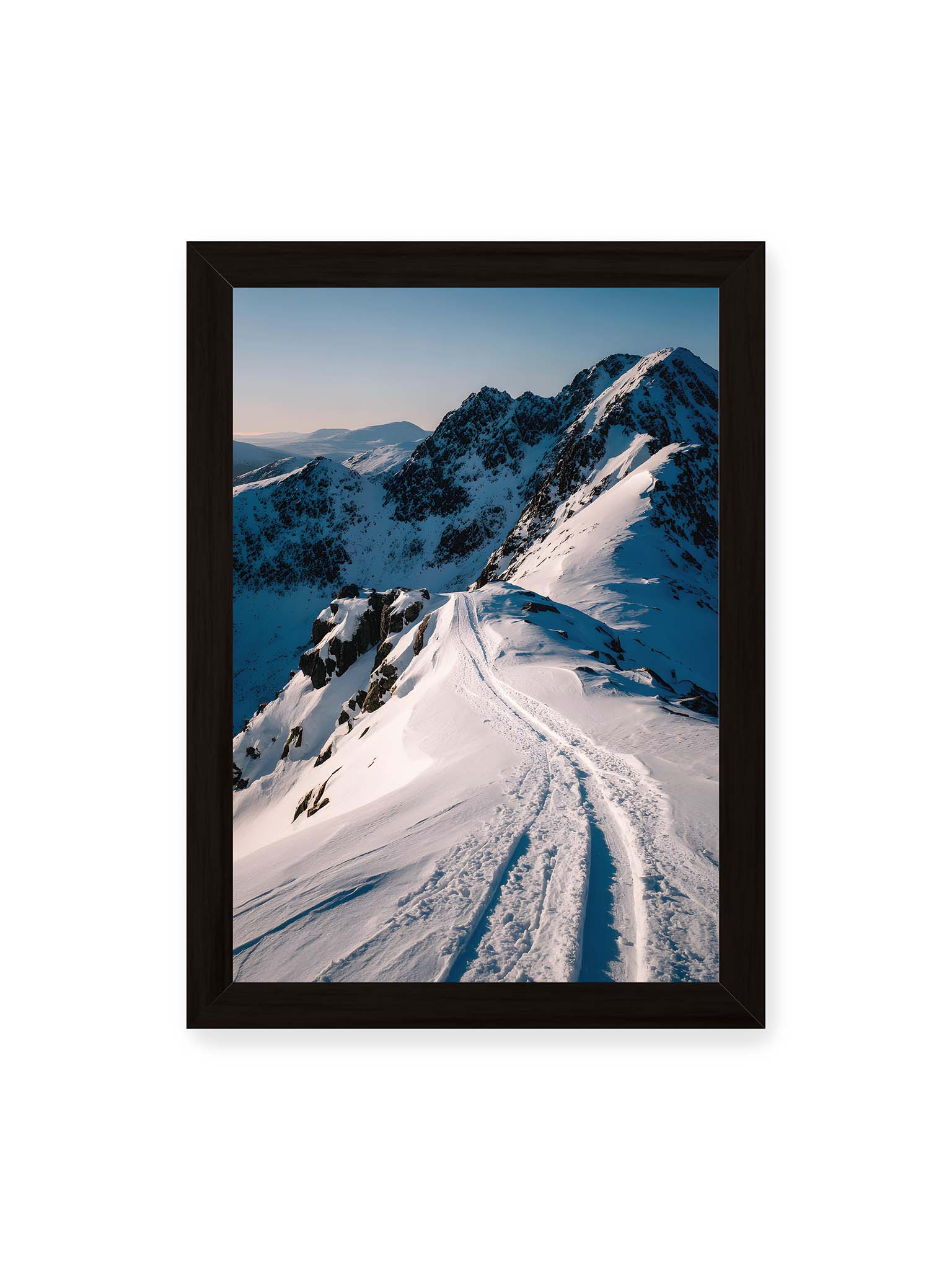 21x30 cm, schwarzer Rahmen – Verschneiter Bergpfad, sanftes Licht beleuchtet die Spuren im Schnee, Berge im Hintergrund.
