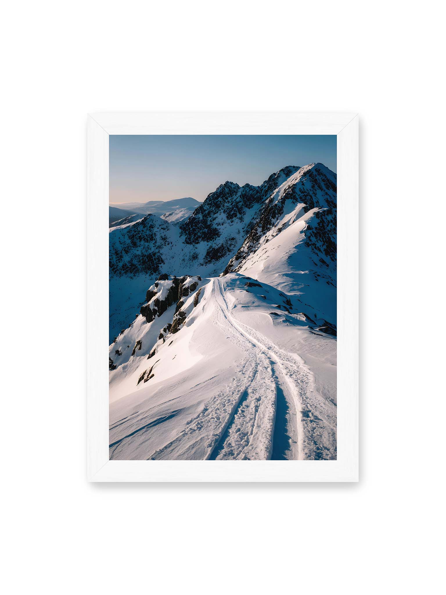 21x30 cm, weißer Rahmen – Verschneiter Bergpfad, sanftes Licht beleuchtet die Spuren im Schnee, Berge im Hintergrund.