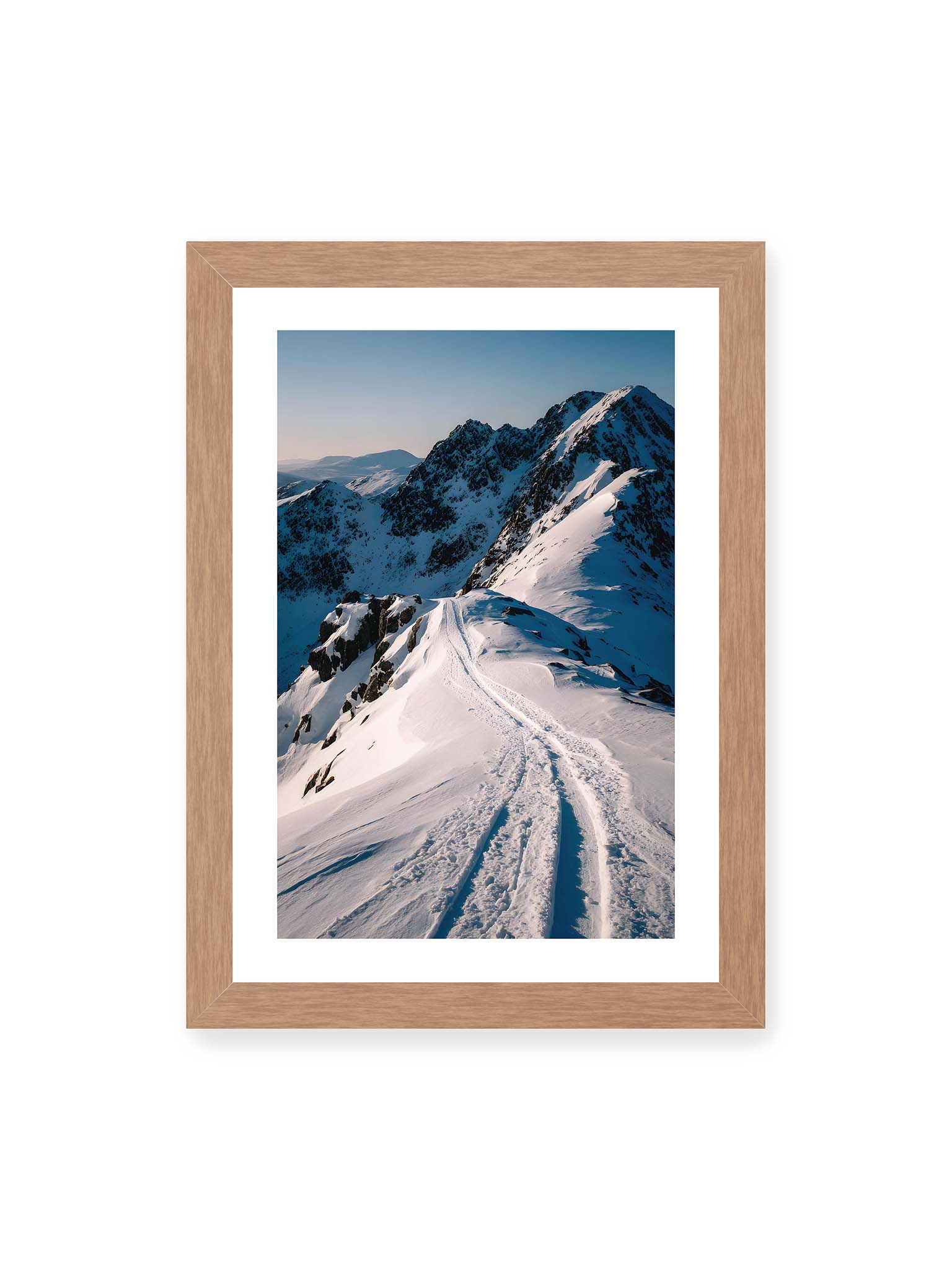 21x30 cm, weißer Galerie-Rand, Eichenrahmen – Verschneiter Bergpfad, sanftes Licht beleuchtet die Spuren im Schnee, Berge im Hintergrund.