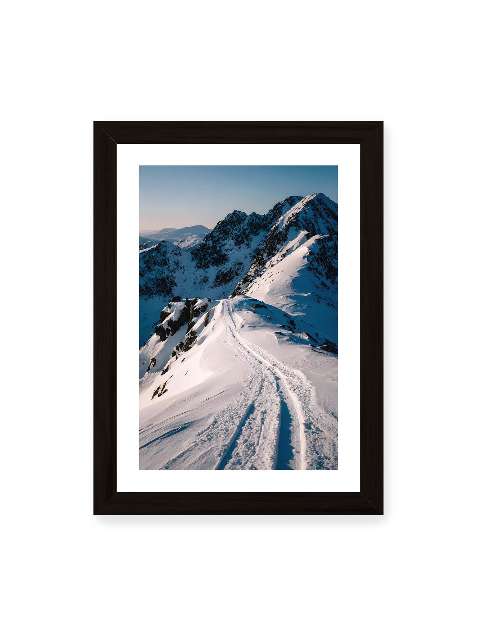 21x30 cm, weißer Galerie-Rand, schwarzer Rahmen – Verschneiter Bergpfad, sanftes Licht beleuchtet die Spuren im Schnee, Berge im Hintergrund.