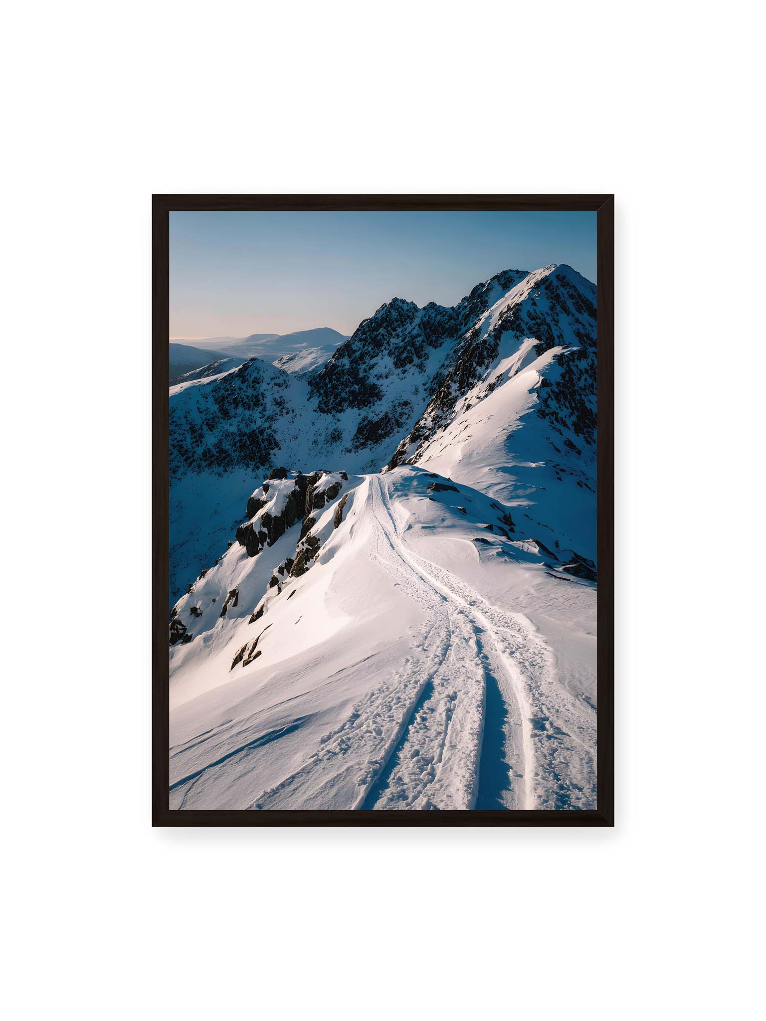 50x70 cm, schwarzer Rahmen – Verschneiter Bergpfad, sanftes Licht beleuchtet die Spuren im Schnee, Berge im Hintergrund.