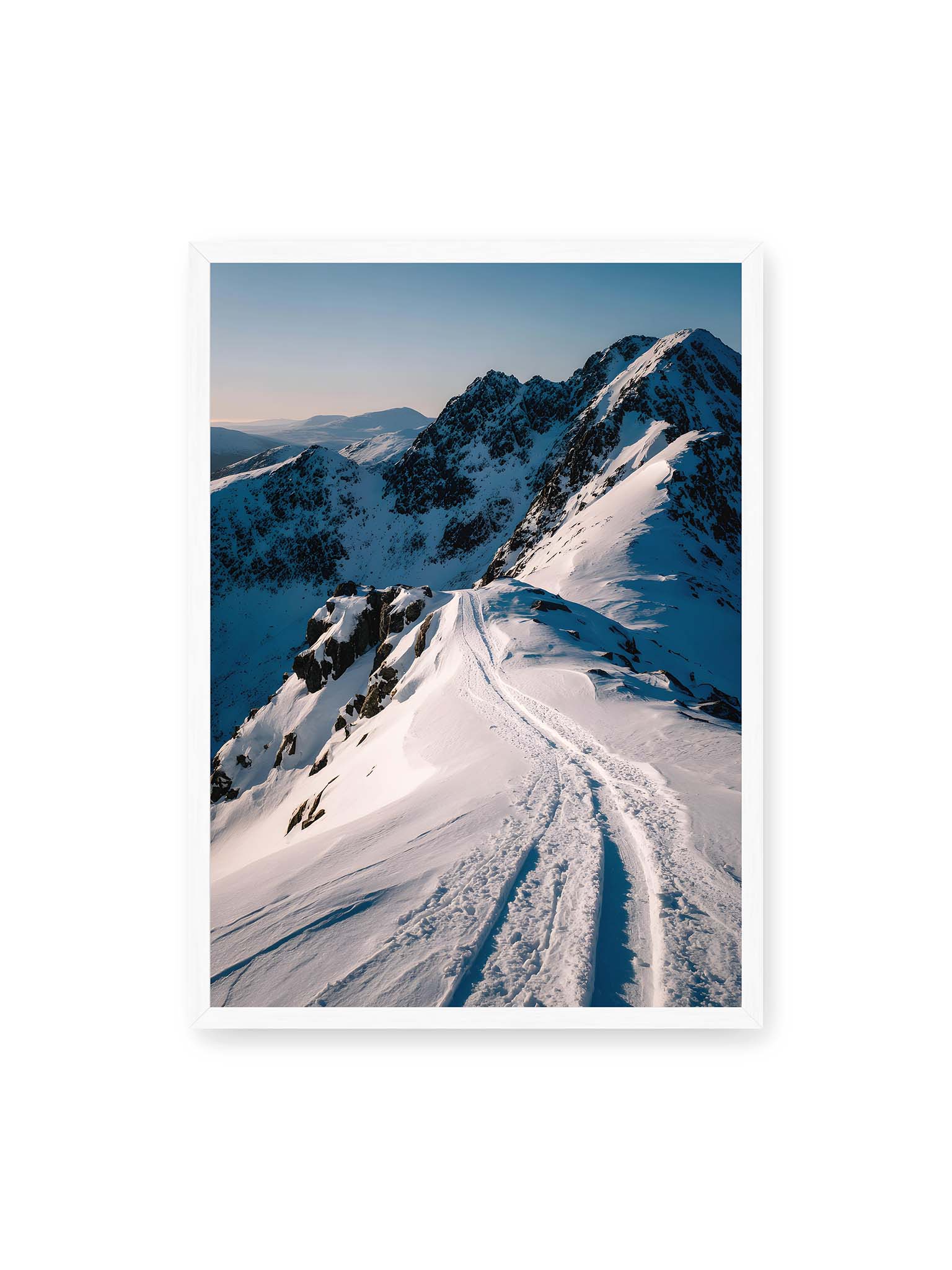 50x70 cm, weißer Rahmen – Verschneiter Bergpfad, sanftes Licht beleuchtet die Spuren im Schnee, Berge im Hintergrund.