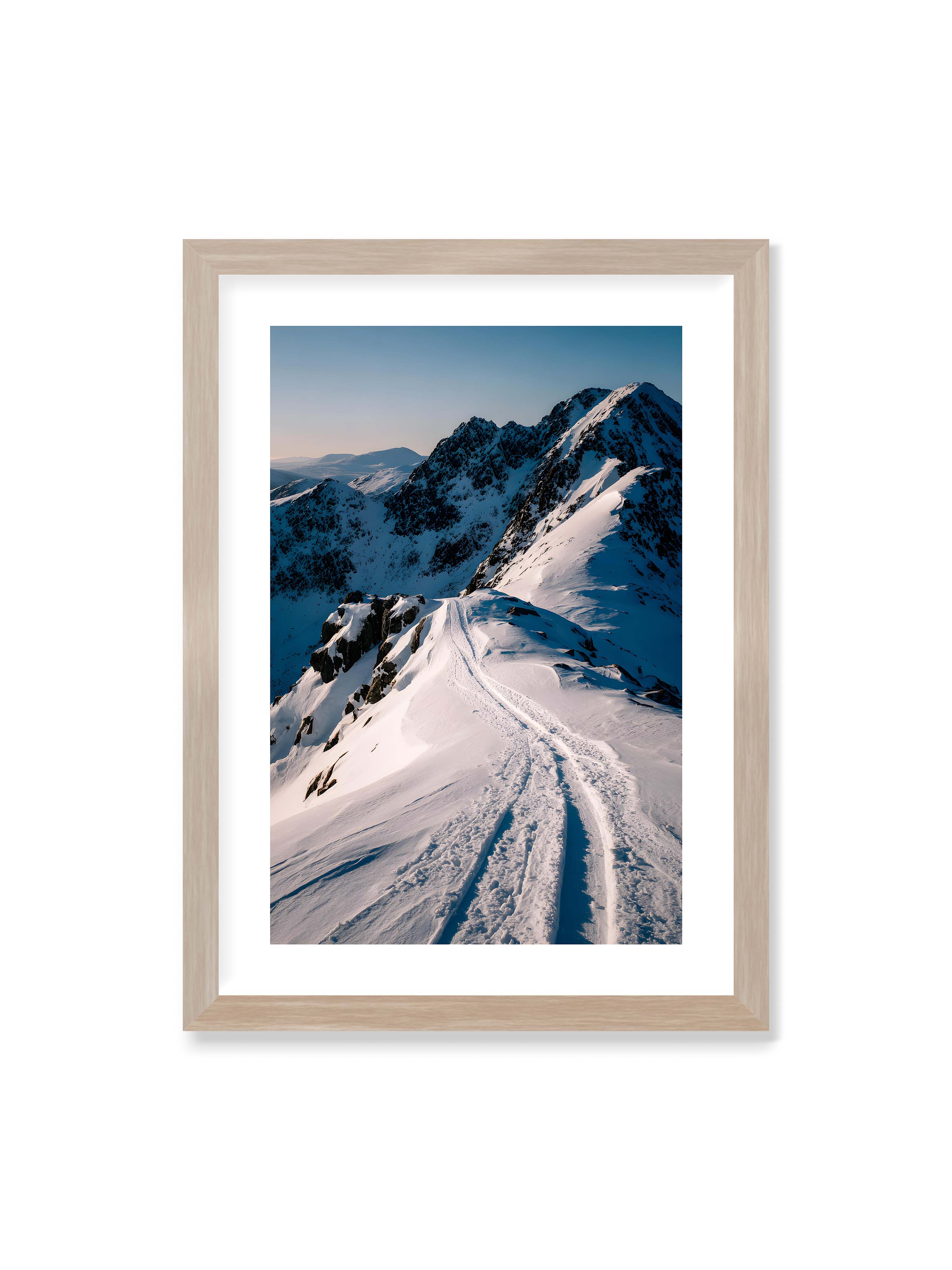 50x70 cm mit weißem Galerie-Rand im Eichenrahmen – Verschneiter Bergpfad, sanftes Licht beleuchtet die Spuren im Schnee, Berge im Hintergrund.