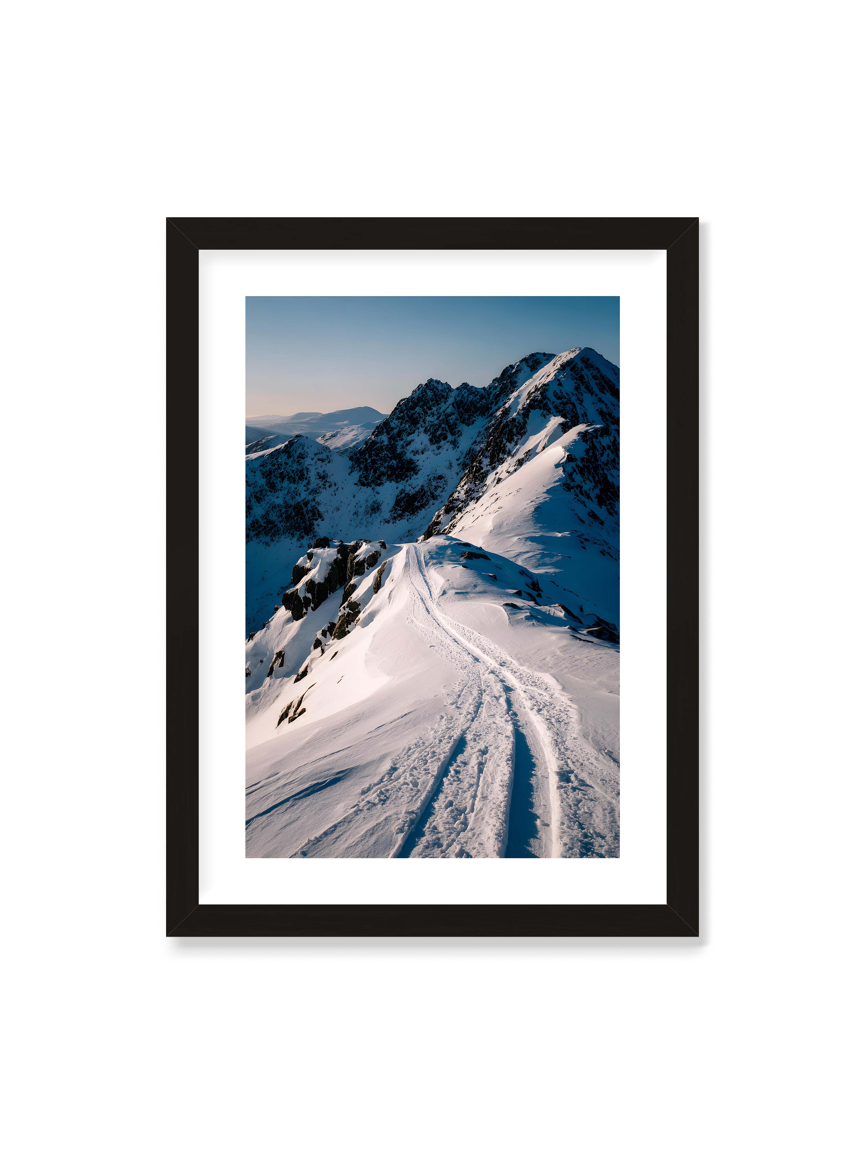 50x70 cm mit weißem Galerie-Rand mit schwarzem Rahmen – Verschneiter Bergpfad, sanftes Licht beleuchtet die Spuren im Schnee, Berge im Hintergrund.