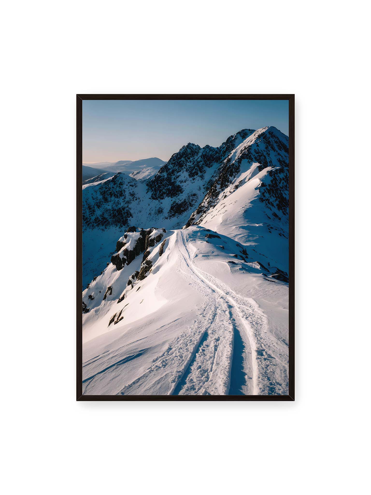 70x100 cm, schwarzer Rahmen – Verschneiter Bergpfad, sanftes Licht beleuchtet die Spuren im Schnee, Berge im Hintergrund.