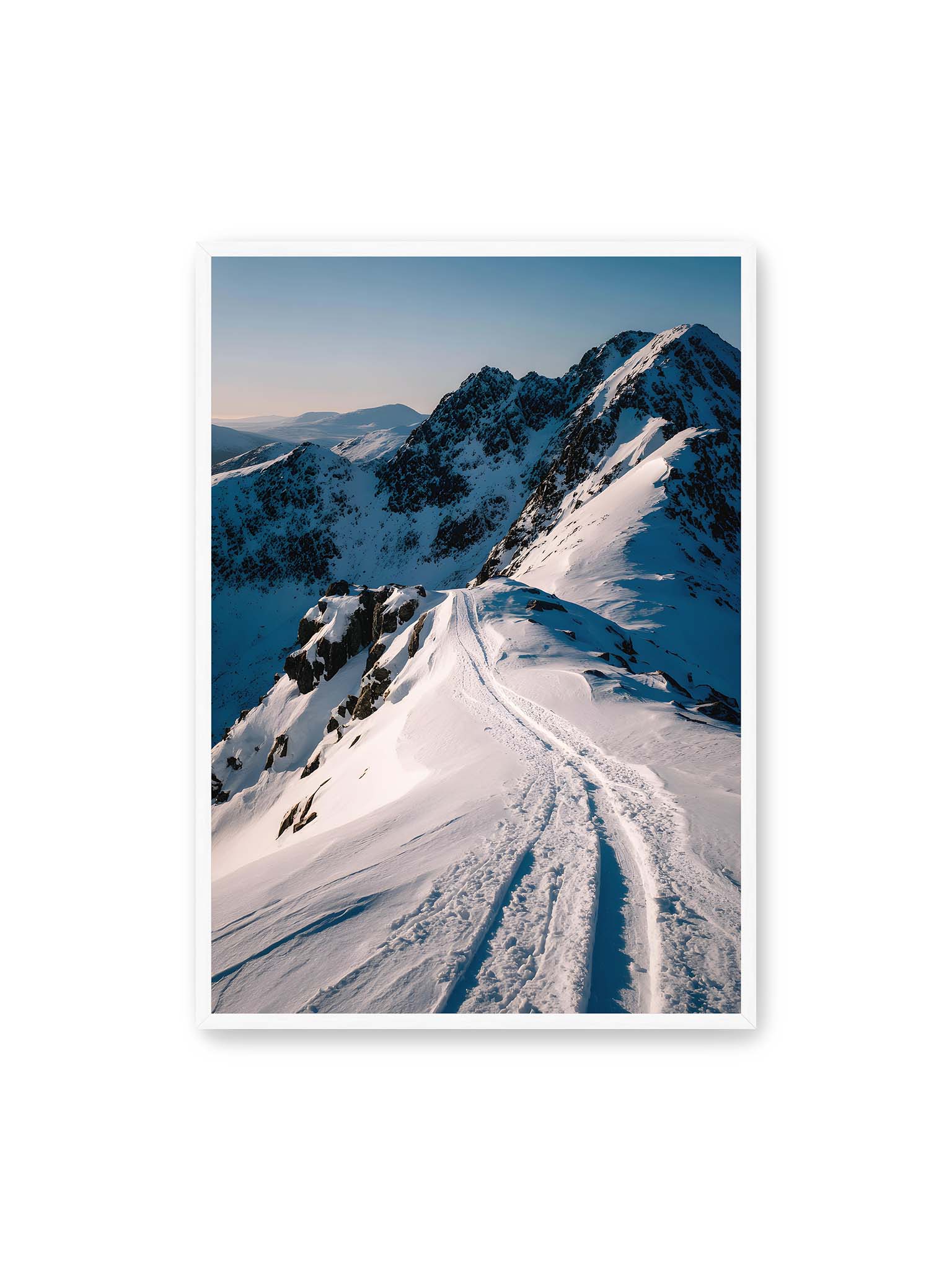 70x100 cm, weißer Rahmen – Verschneiter Bergpfad, sanftes Licht beleuchtet die Spuren im Schnee, Berge im Hintergrund.