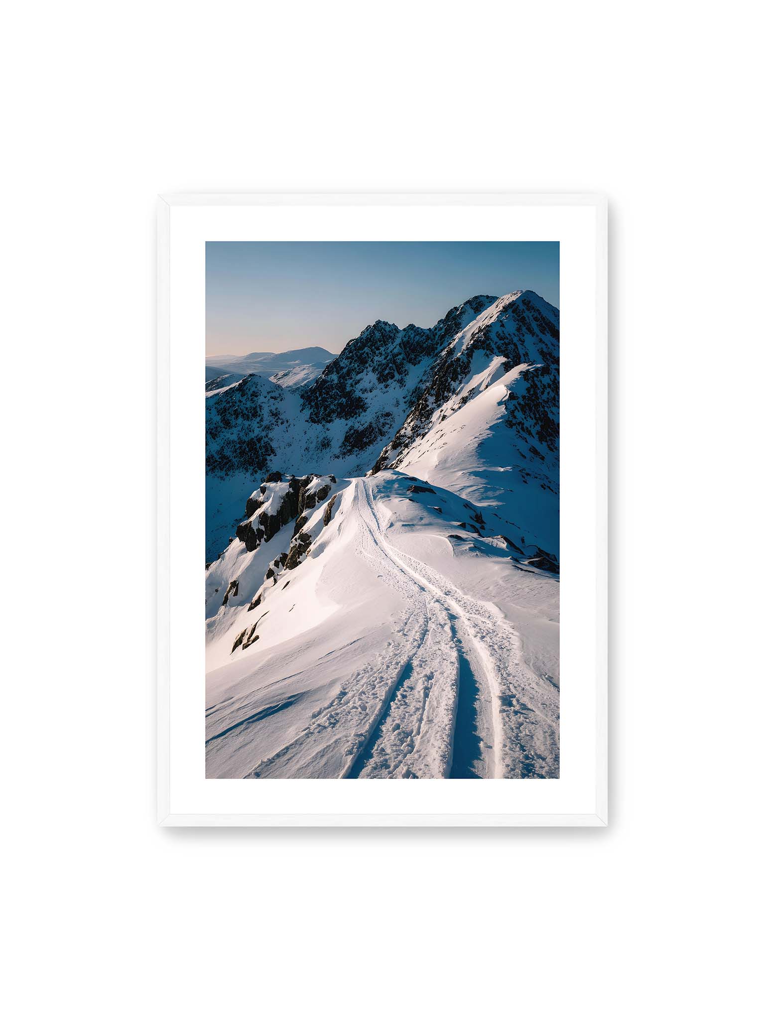 70x100 cm, weißer Galerie-Rand, weißer Rahmen – Verschneiter Bergpfad, sanftes Licht beleuchtet die Spuren im Schnee, Berge im Hintergrund.