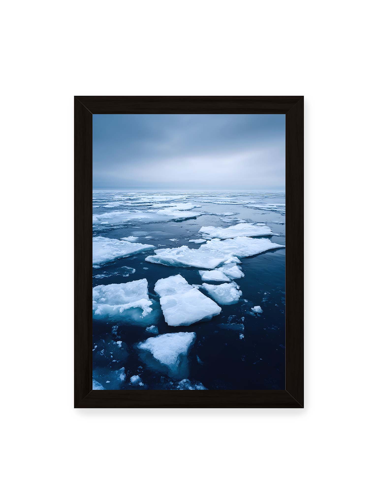 21x30 cm, schwarzer Rahmen – Zerbrochene Eisschollen treiben auf dunklem Wasser unter bewölktem Himmel.