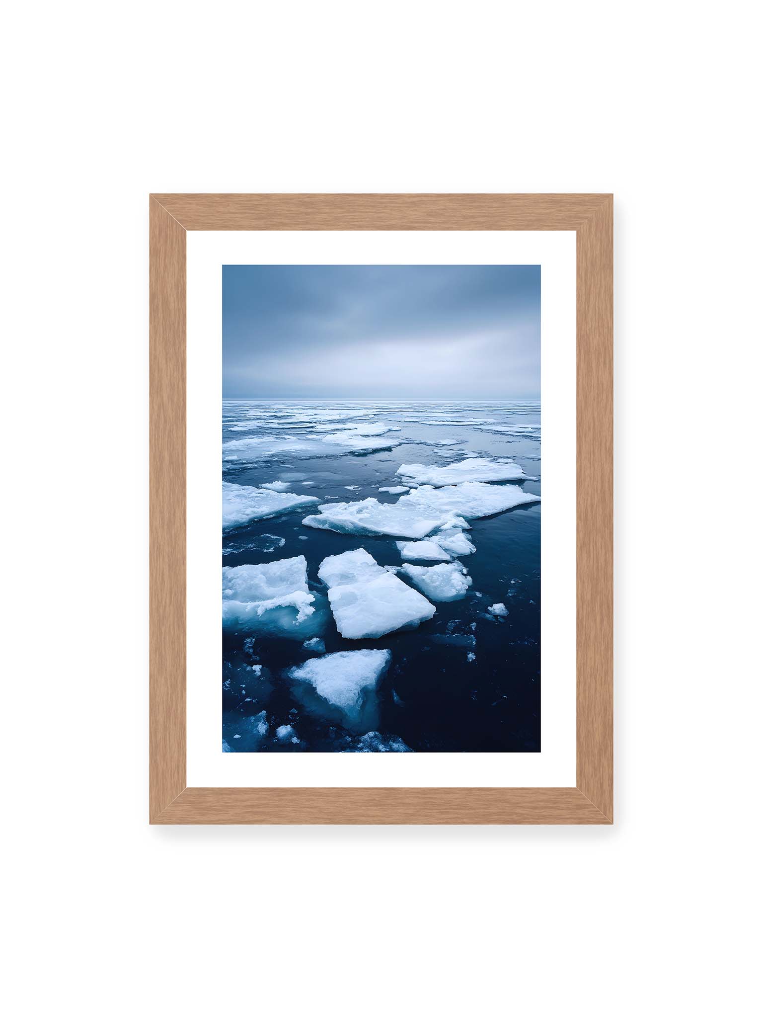 21x30 cm, weißer Galerie-Rand, Eichenrahmen – Zerbrochene Eisschollen treiben auf dunklem Wasser unter bewölktem Himmel.