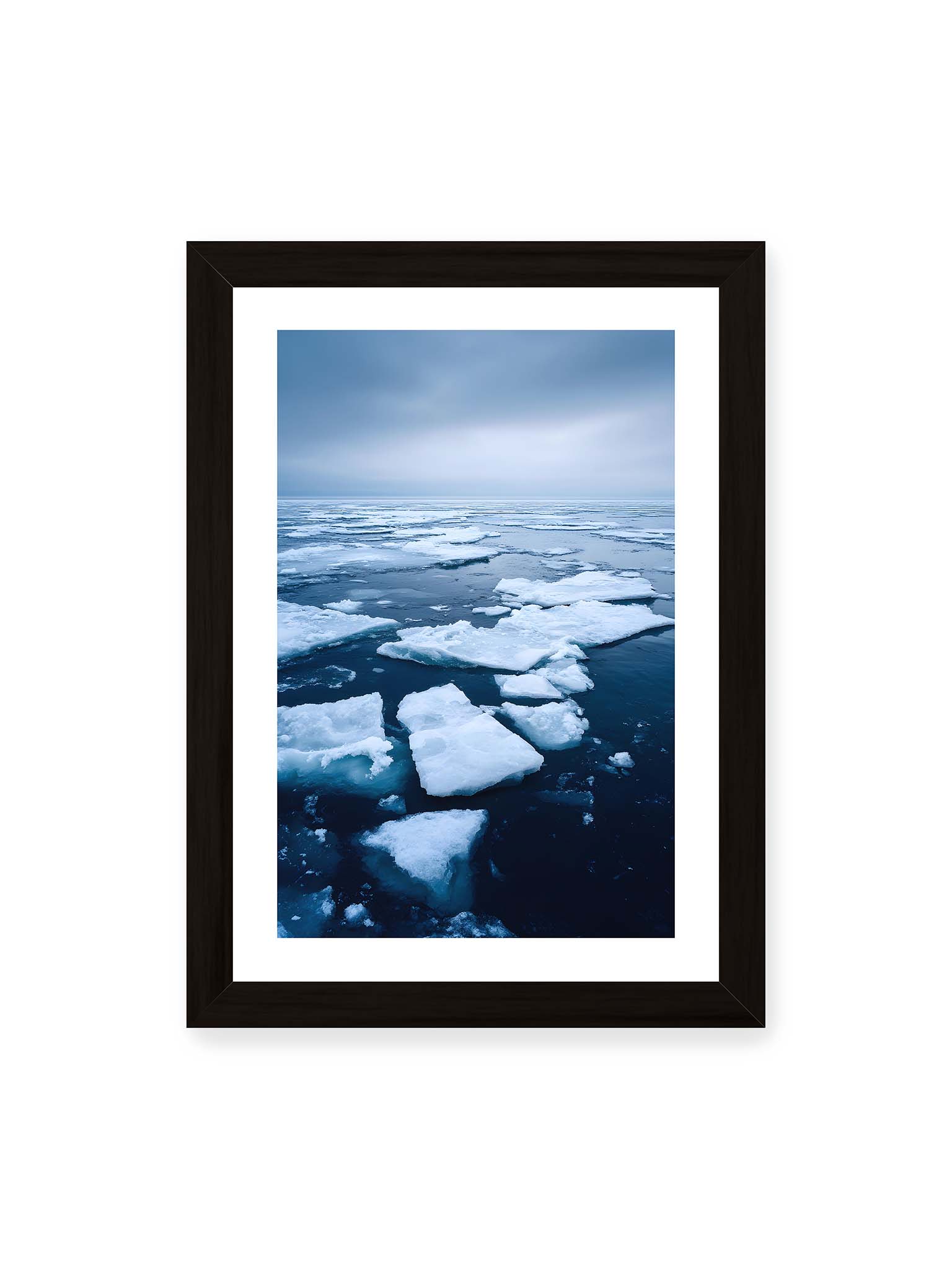 21x30 cm, weißer Galerie-Rand, schwarzer Rahmen – Zerbrochene Eisschollen treiben auf dunklem Wasser unter bewölktem Himmel.