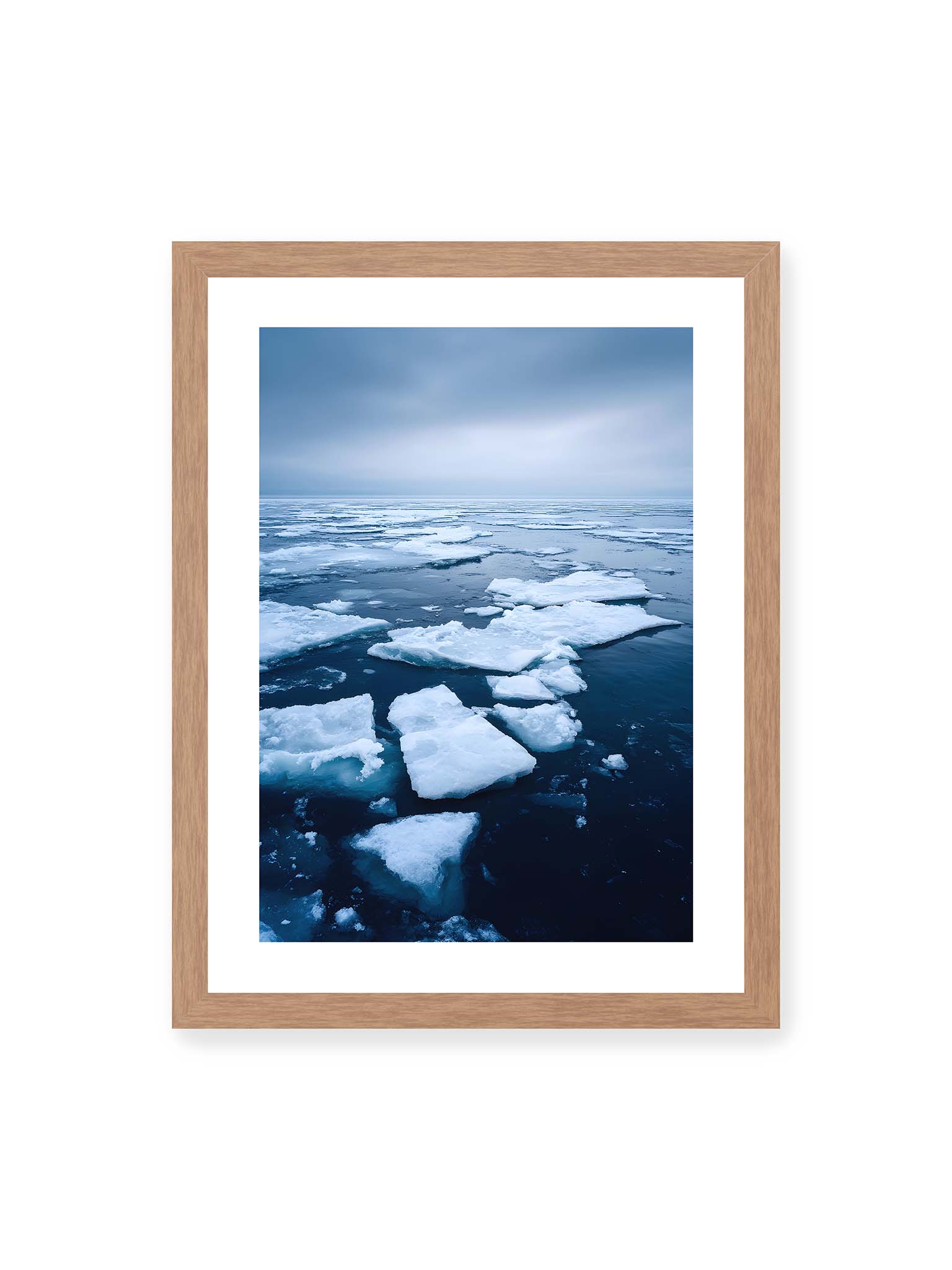 30x40 cm, weißer Galerie-Rand, Eichenrahmen – Zerbrochene Eisschollen treiben auf dunklem Wasser unter bewölktem Himmel.