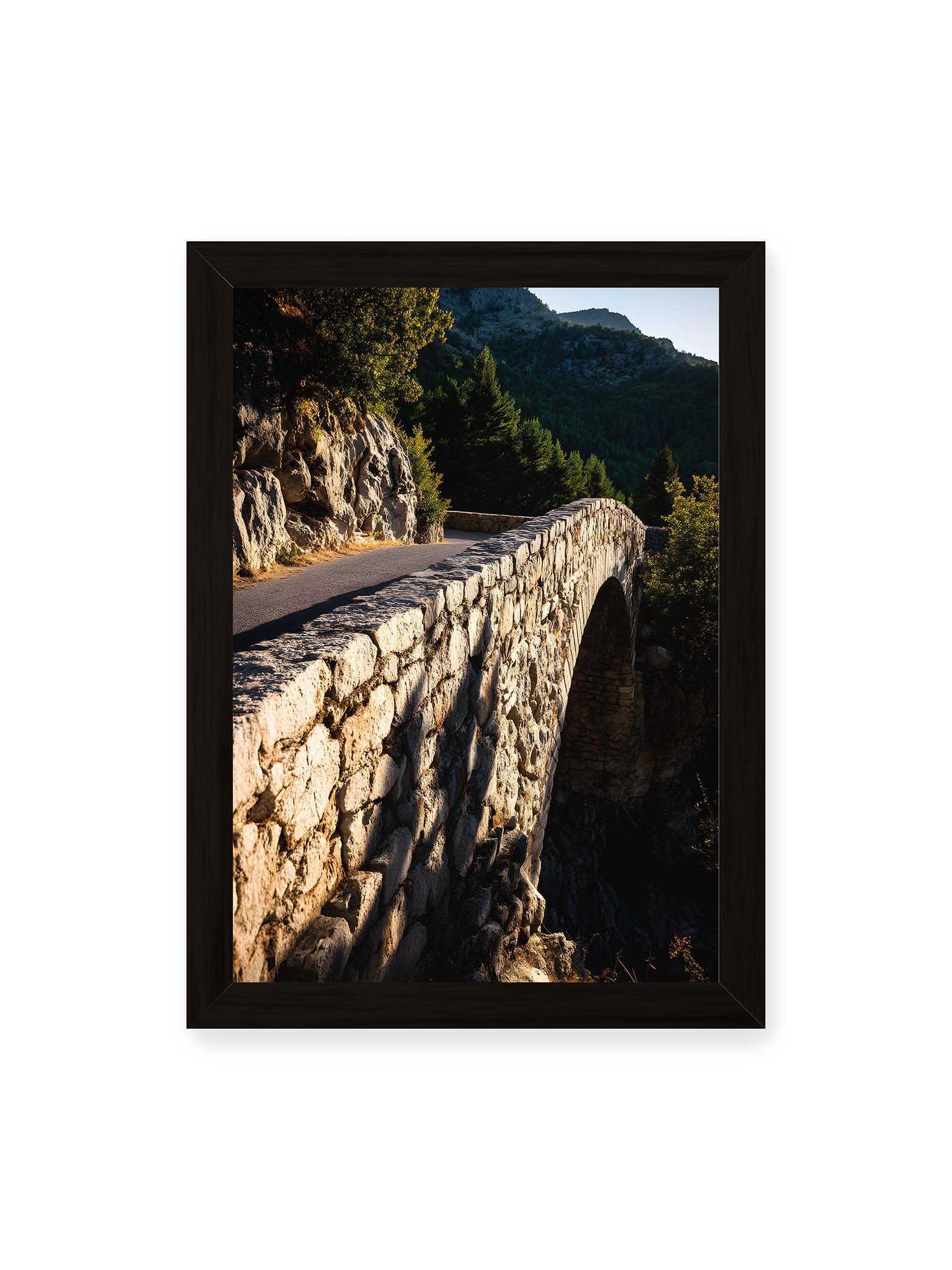 21x30 cm, schwarzer Rahmen – Steinbrücke mit architektonischem Bogen, beleuchtet vom Abendlicht, umrahmt von einer grünen Landschaft.