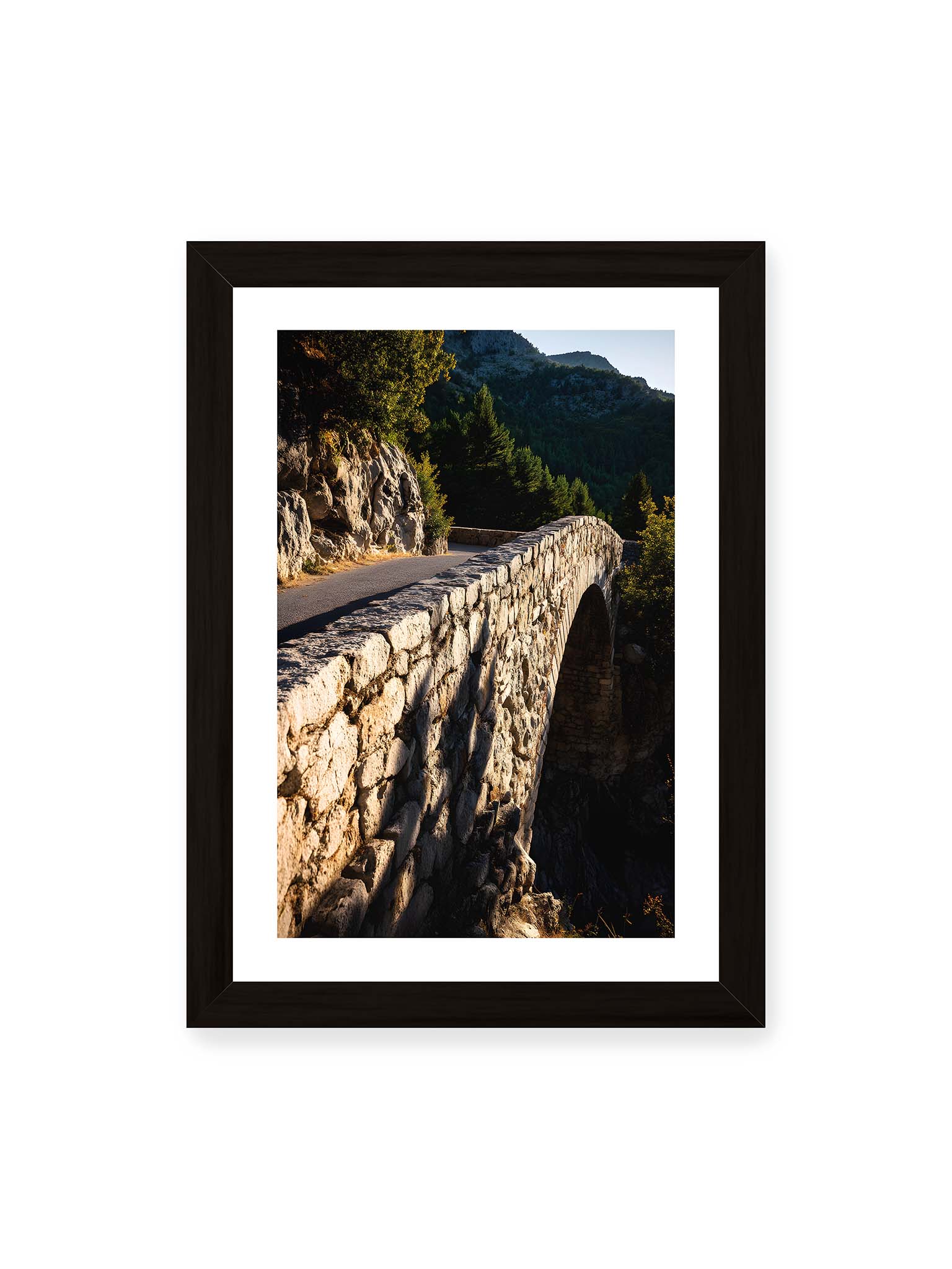 21x30 cm, weißer Galerie-Rand, schwarzer Rahmen – Steinbrücke mit architektonischem Bogen, beleuchtet vom Abendlicht, umrahmt von einer grünen Landschaft.
