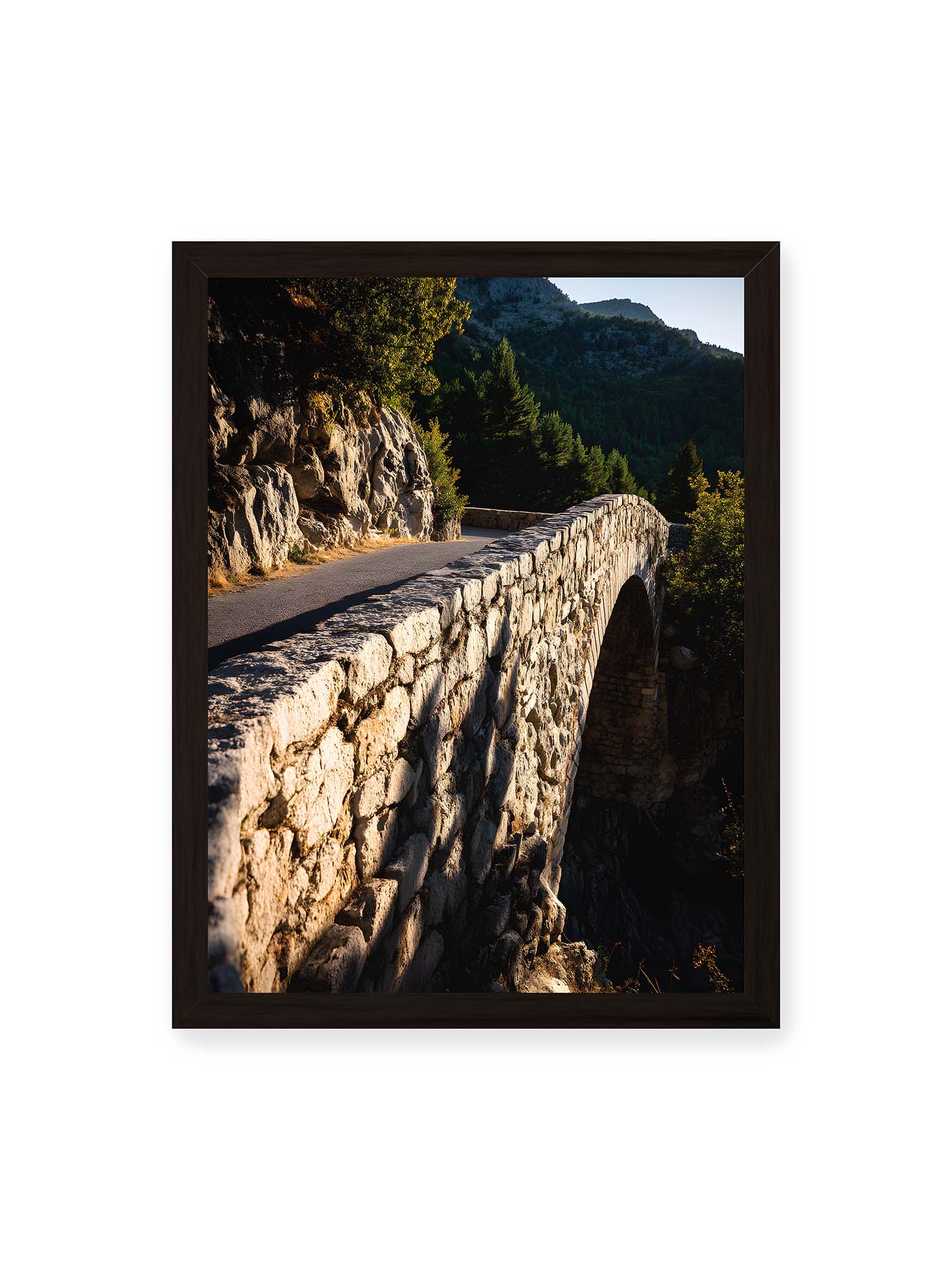 30x40 cm, schwarzer Rahmen – Steinbrücke mit architektonischem Bogen, beleuchtet vom Abendlicht, umrahmt von einer grünen Landschaft.