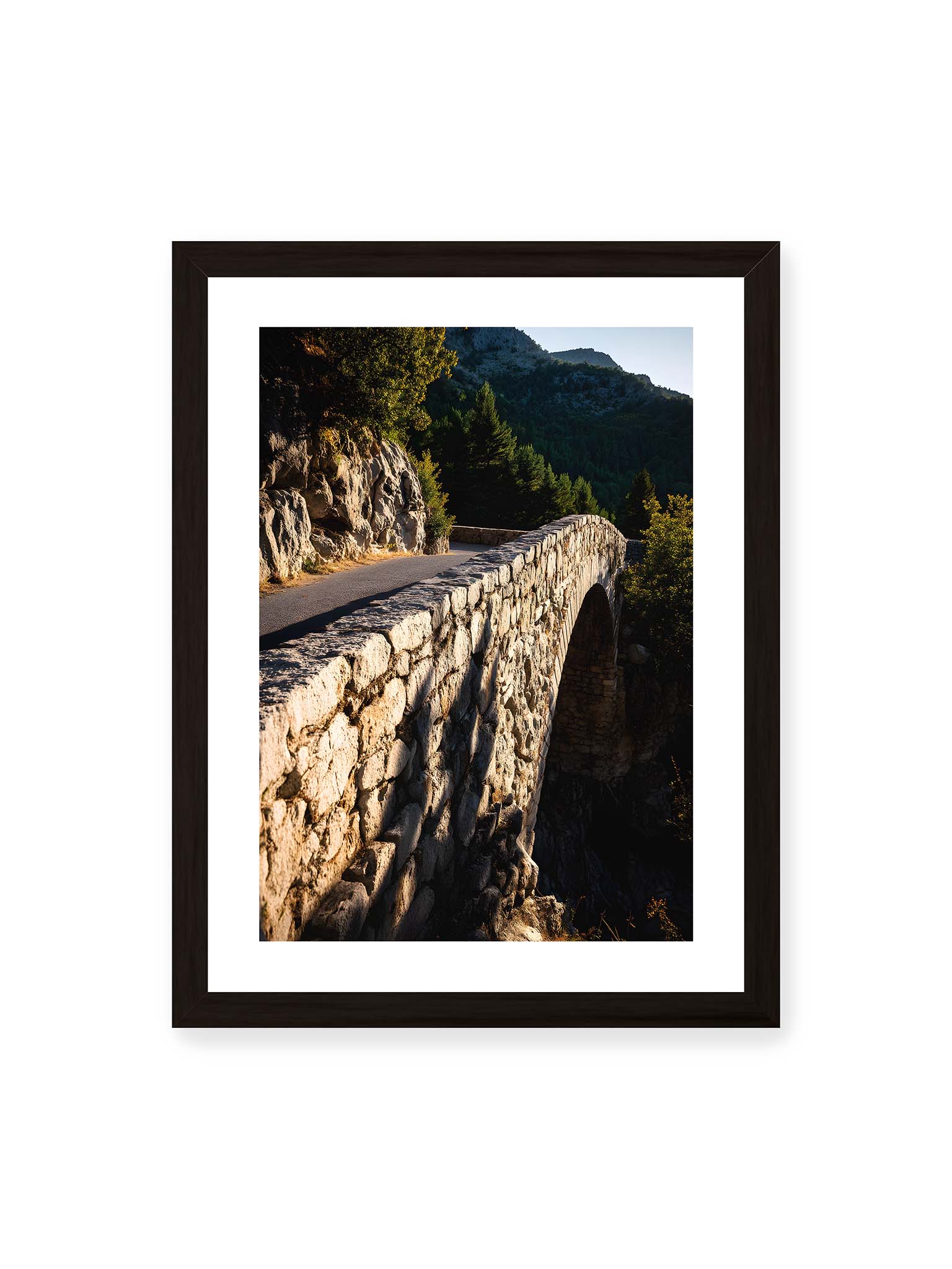 30x40 cm, weißer Galerie-Rand, schwarzer Rahmen – Steinbrücke mit architektonischem Bogen, beleuchtet vom Abendlicht, umrahmt von einer grünen Landschaft.