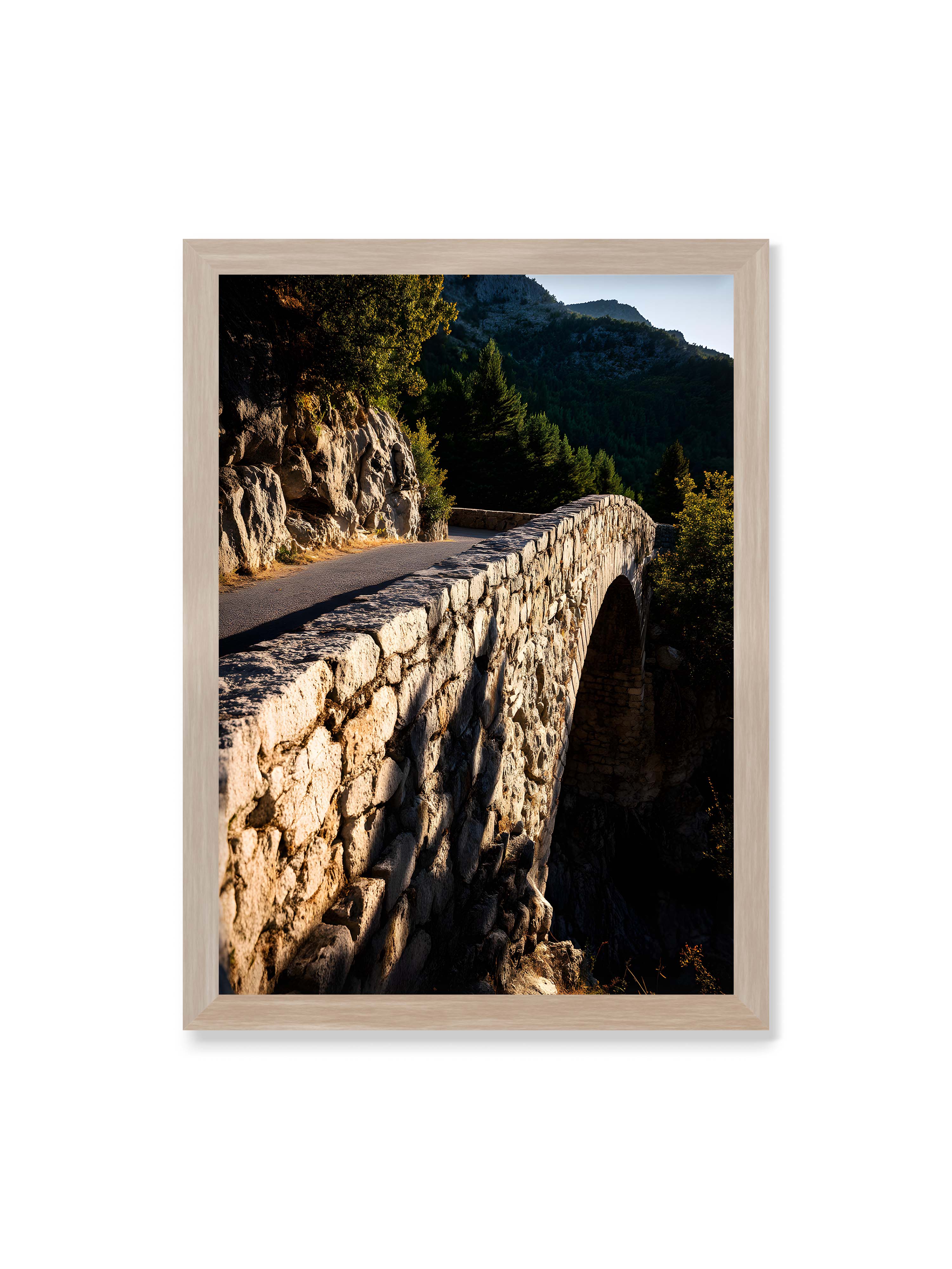 50x70 cm ohne Galerie-Rand im Eichenrahmen – Steinbrücke mit architektonischem Bogen, beleuchtet vom Abendlicht, umrahmt von einer grünen Landschaft.
