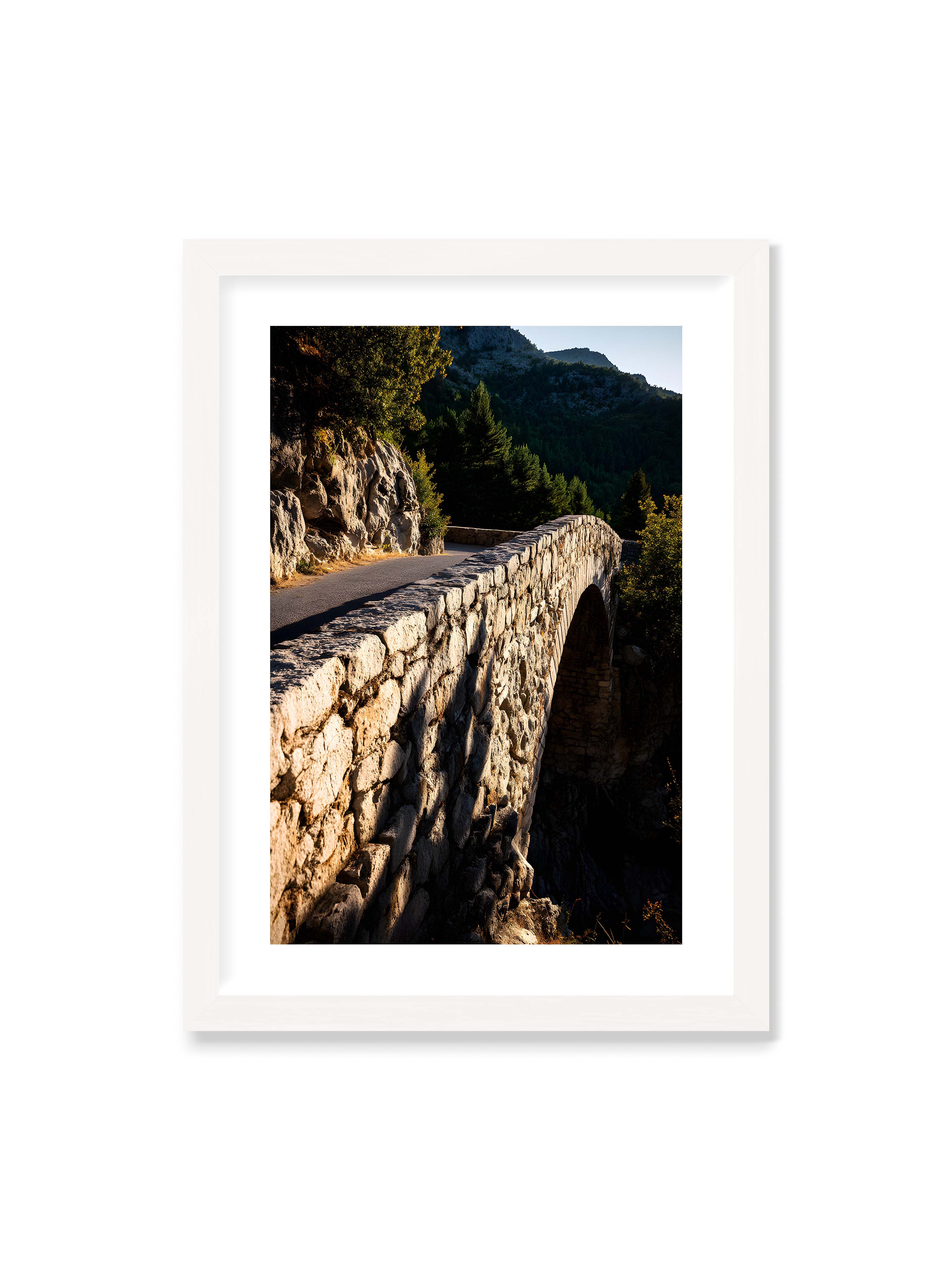 50x70 cm mit weißem Galerie-Rand mit weißem Rahmen – Steinbrücke mit architektonischem Bogen, beleuchtet vom Abendlicht, umrahmt von einer grünen Landschaft.