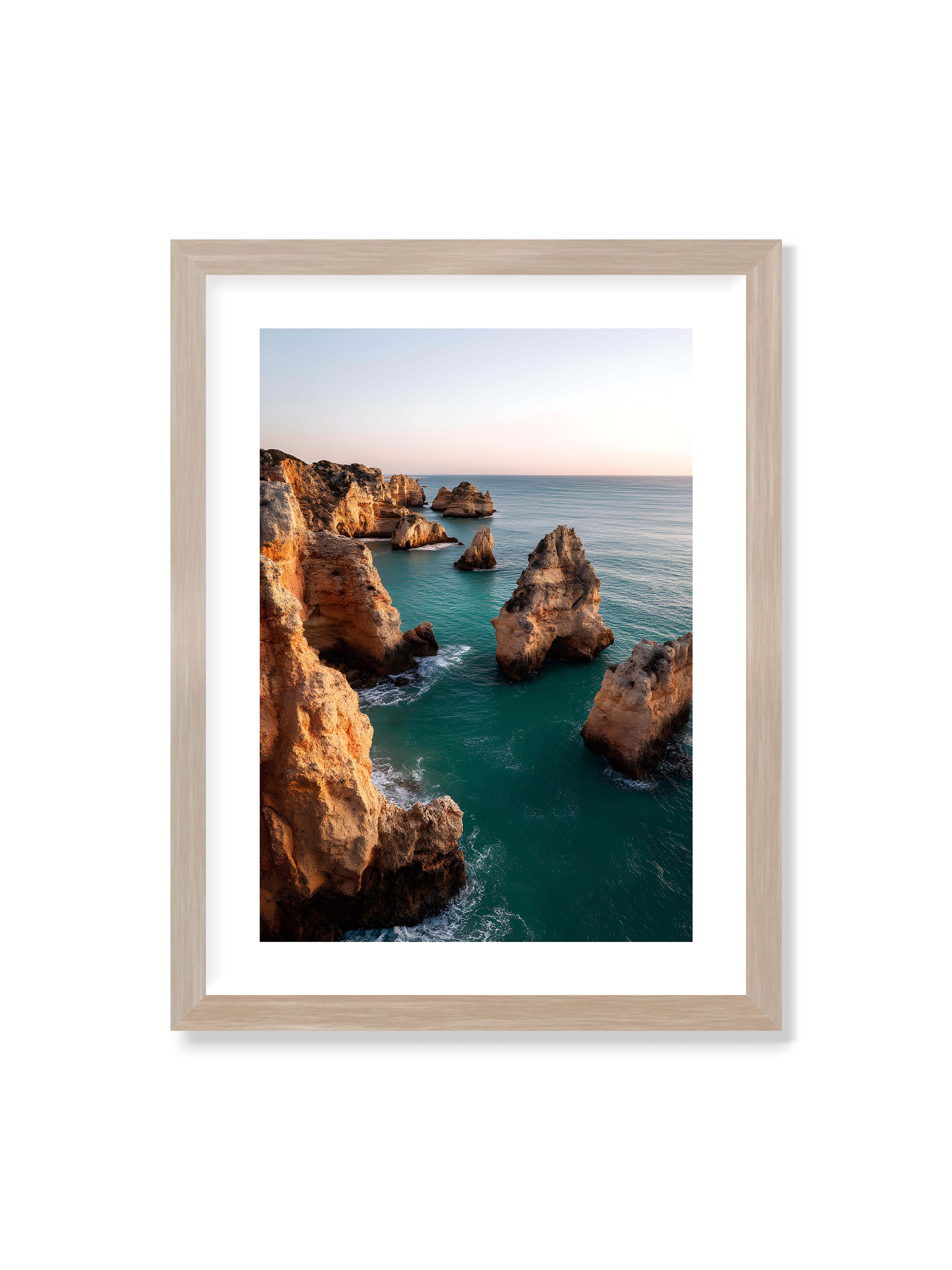 30x40 cm mit weißem Galerie-Rand im Eichenrahmen – Felsformationen an der Küste, umgeben von azurblauem Wasser und goldenem Licht des späten Nachmittags.