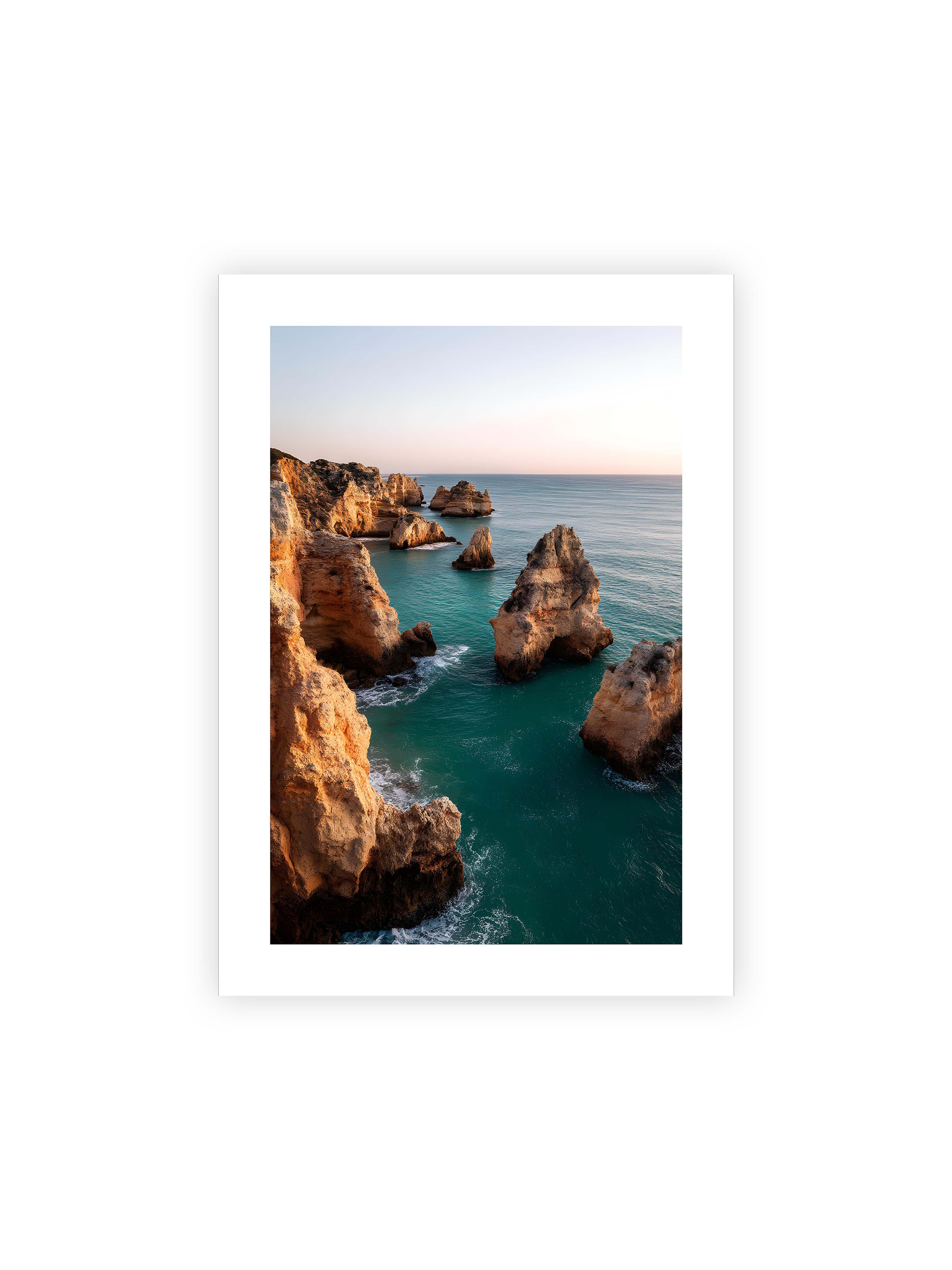 50x70 cm mit weißem Galerie-Rand ohne Rahmen – Felsformationen an der Küste, umgeben von azurblauem Wasser und goldenem Licht des späten Nachmittags.