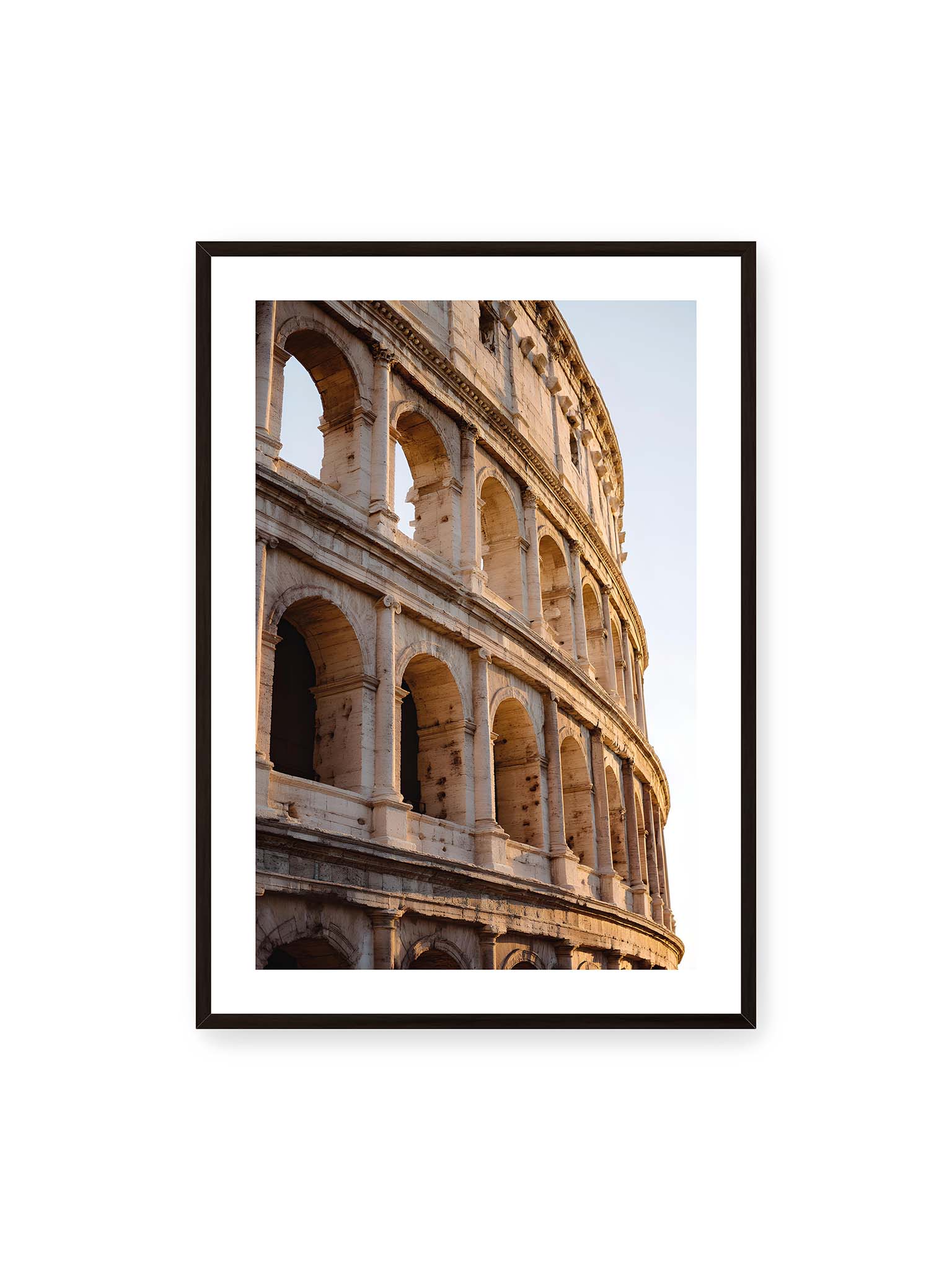 70x100 cm, weißer Galerie-Rand, schwarzer Rahmen – Nahaufnahme des Kolosseums in Rom mit seinen beeindruckenden Bögen im sanften Licht des Sonnenuntergangs.