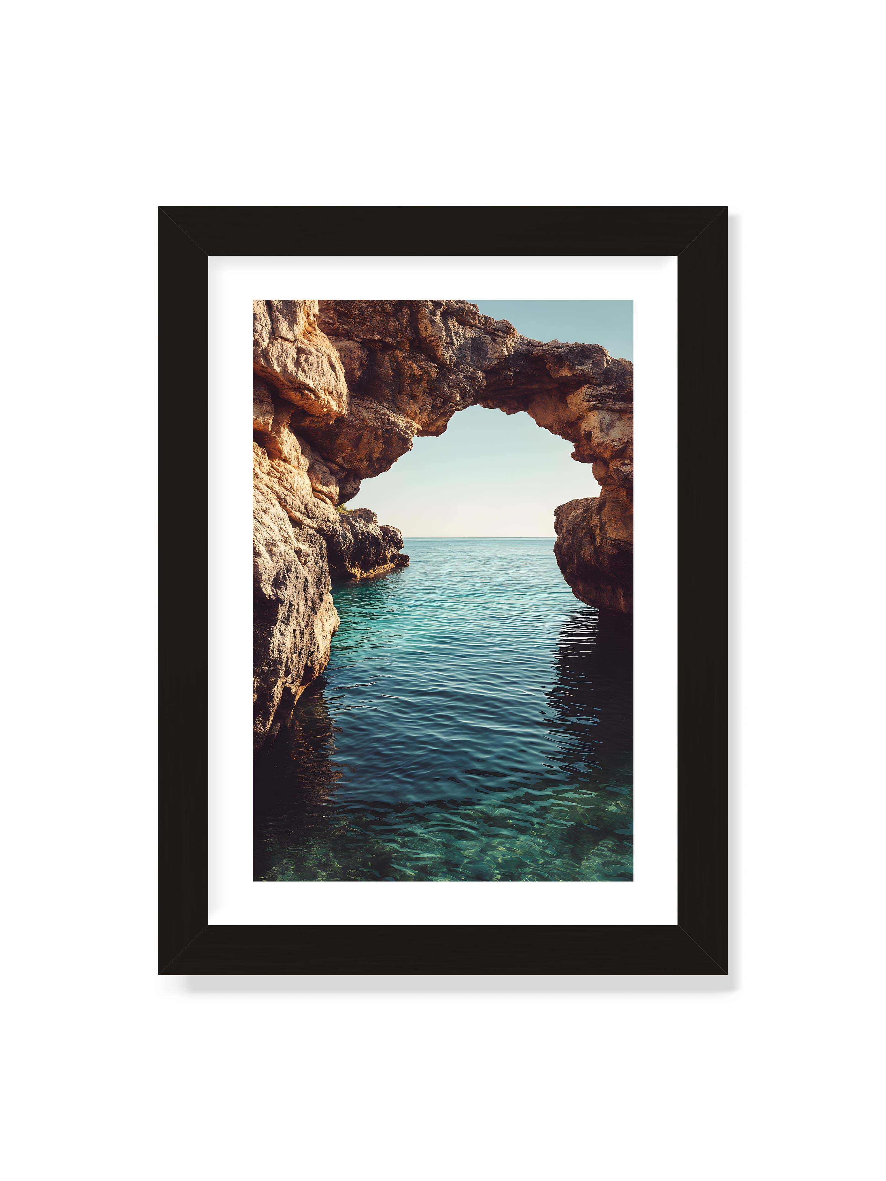 21x30 cm mit weißem Galerie-Rand mit schwarzem Rahmen – Felsenbogen mit Blick auf das klare, türkisfarbene Meer und die weite Küstenlandschaft.