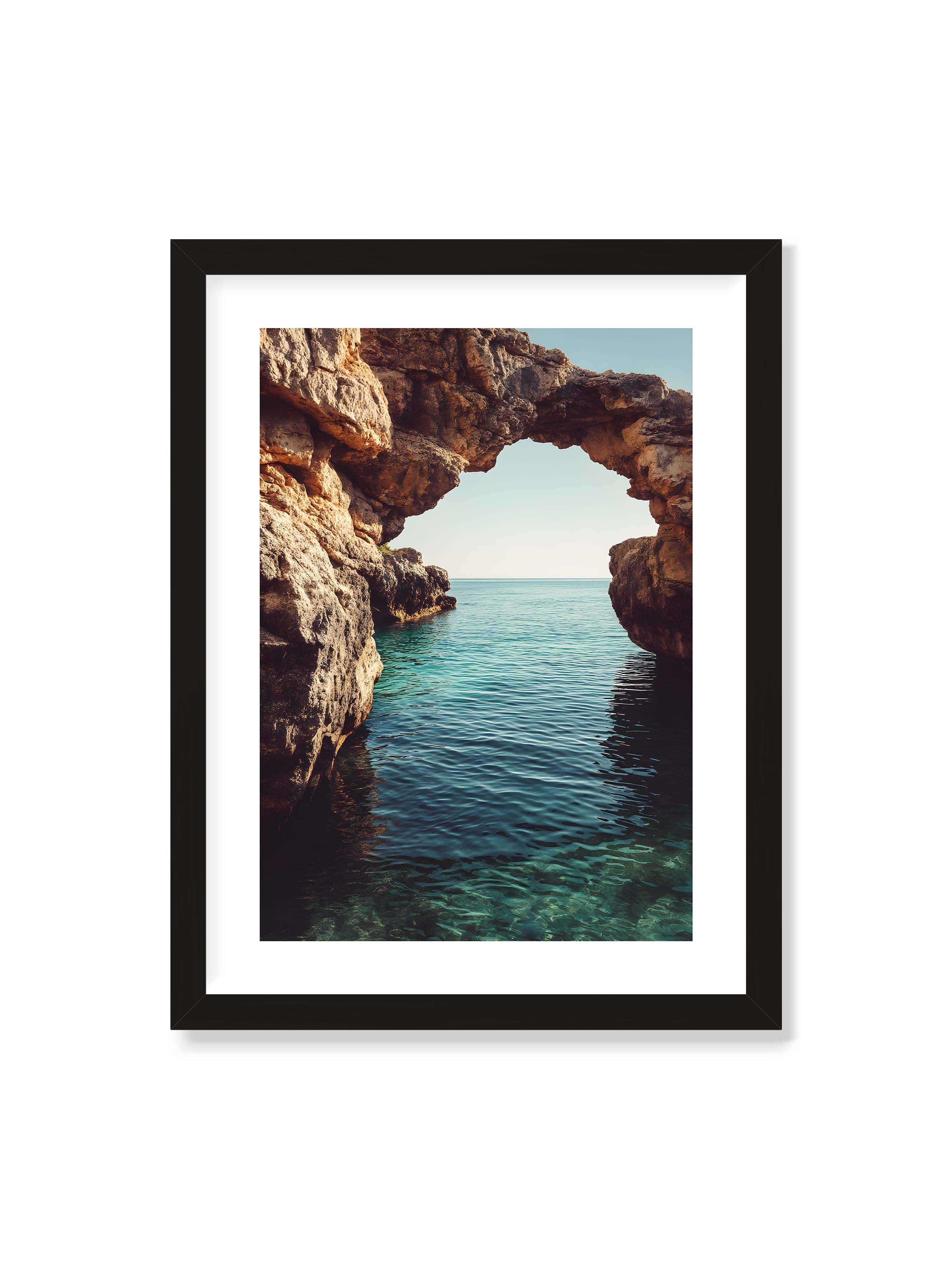 30x40 cm mit weißem Galerie-Rand mit schwarzem Rahmen – Felsenbogen mit Blick auf das klare, türkisfarbene Meer und die weite Küstenlandschaft.