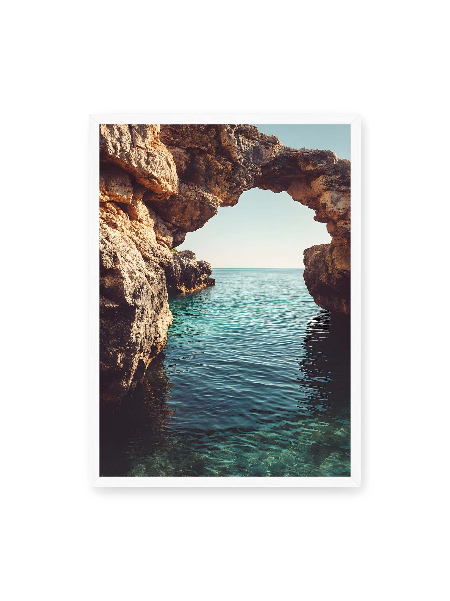 50x70 cm, weißer Rahmen – Felsenbogen mit Blick auf das klare, türkisfarbene Meer und die weite Küstenlandschaft der Algarve.