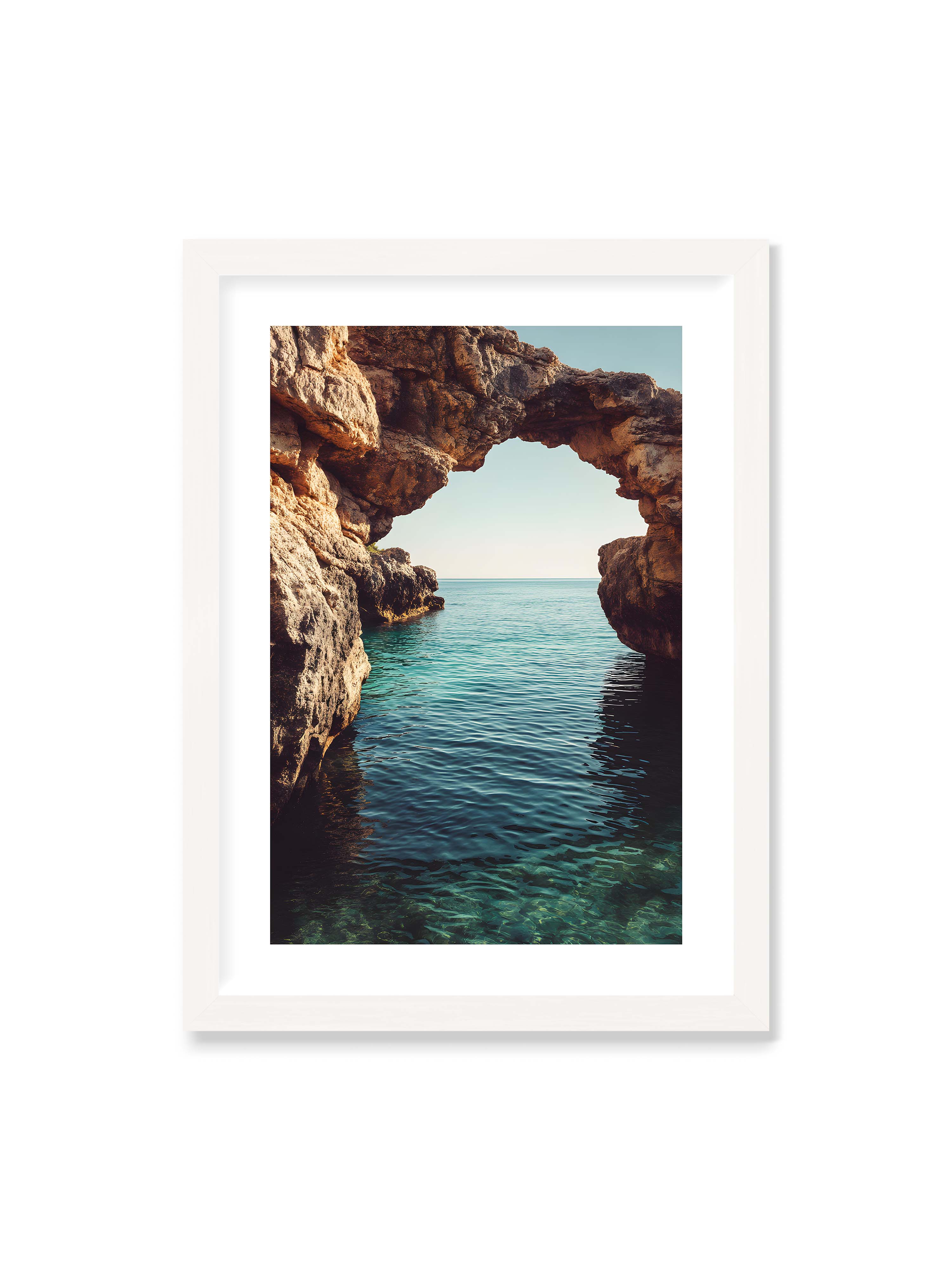 50x70 cm mit weißem Galerie-Rand mit weißem Rahmen – Felsenbogen mit Blick auf das klare, türkisfarbene Meer und die weite Küstenlandschaft.