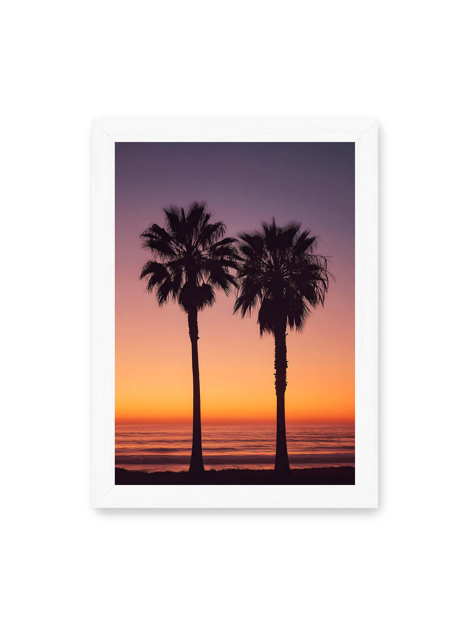 21x30 cm, weißer Rahmen – Zwei Palmensilhouetten vor leuchtendem Orange Lila Sonnenuntergang über dem Meer.