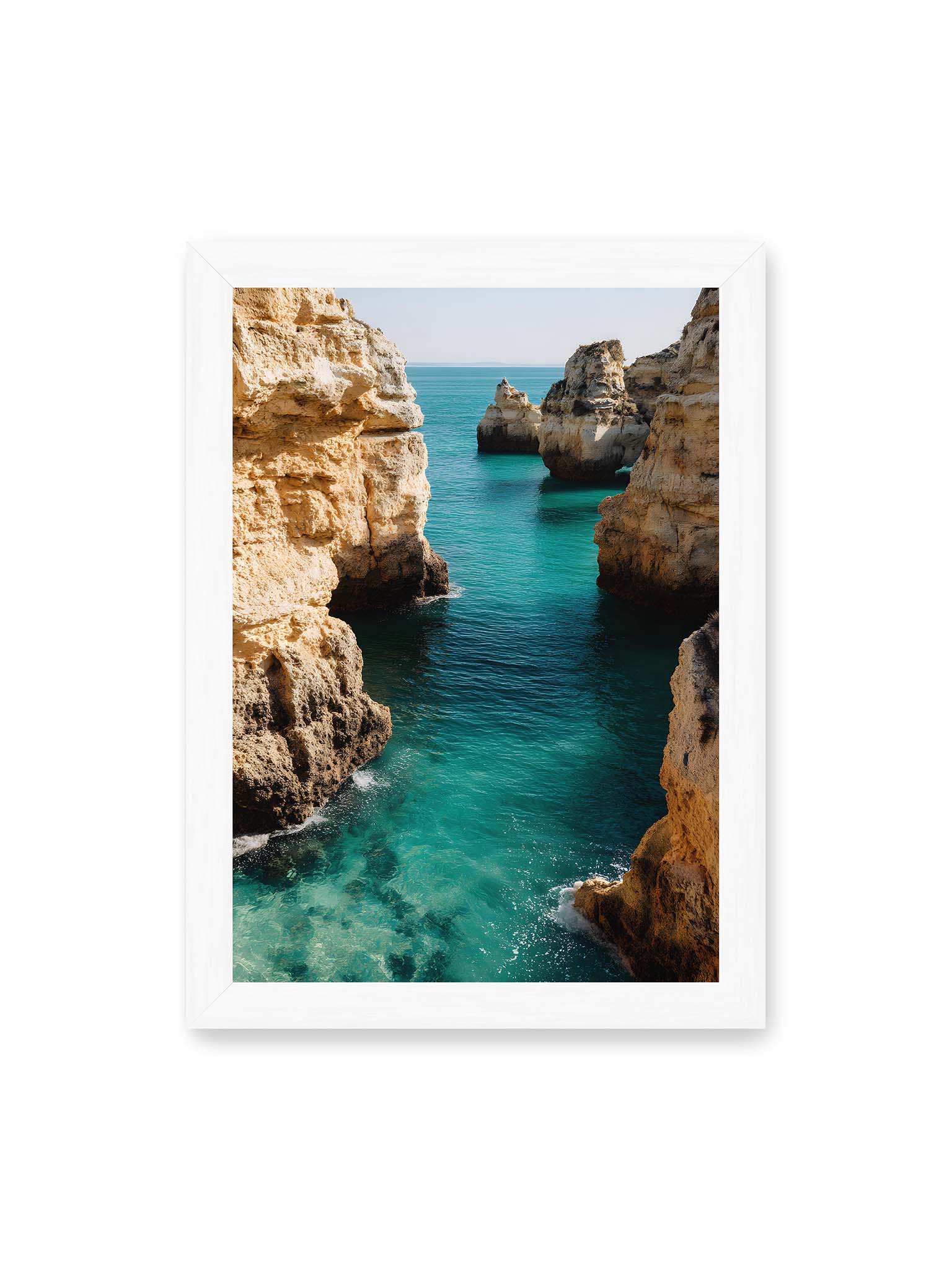 21x30 cm, weißer Rahmen – Mehrere Felsen an einer Küste der Algarve, umgeben von klarem, türkisfarbenem Wasser, das sanft an die Klippen schwappt.