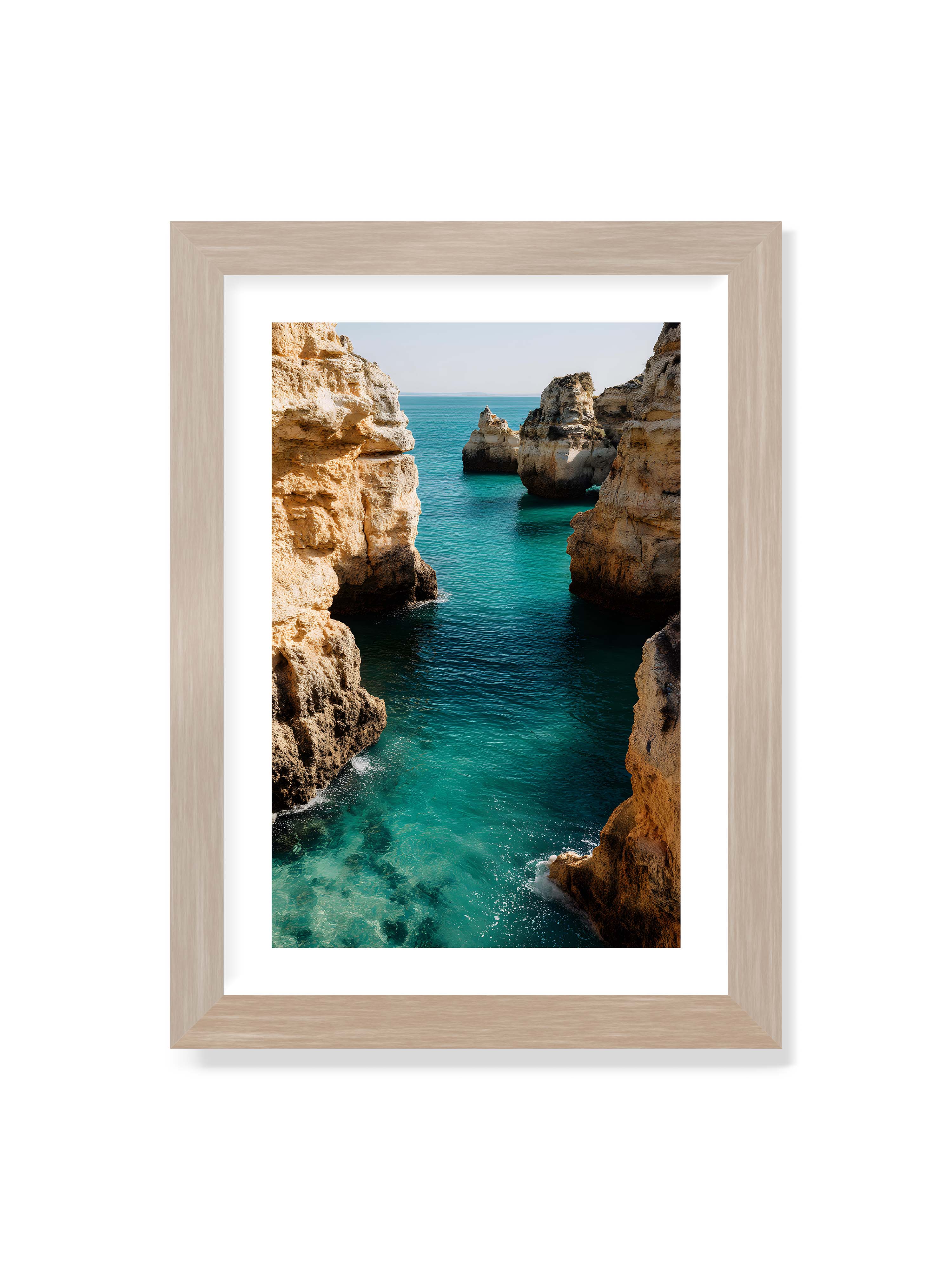 21x30 cm mit weißem Galerie-Rand im Eichenrahmen – Felsen an einer Küste, umgeben von klarem, türkisfarbenem Wasser, das sanft an die Klippen schwappt.