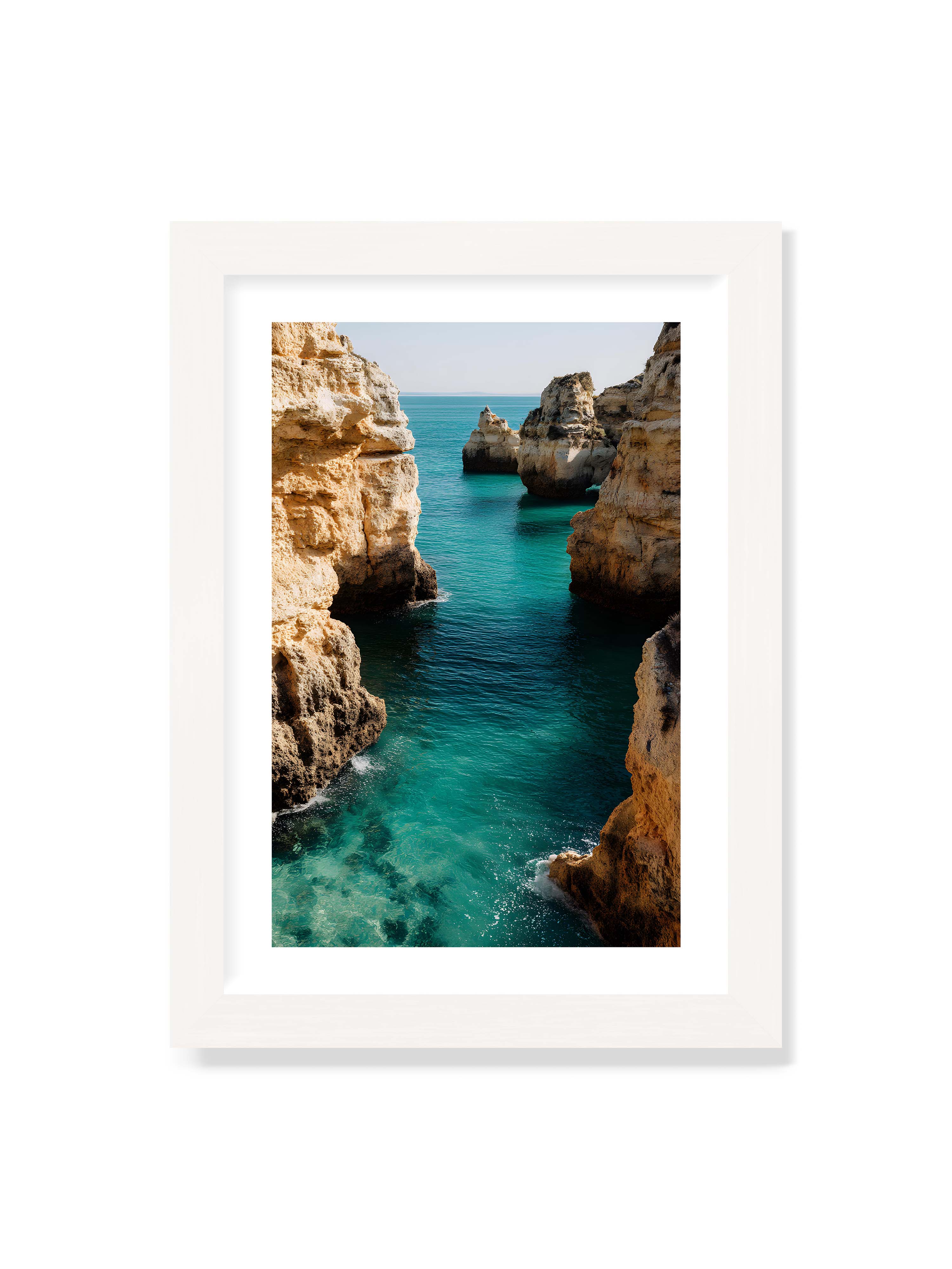 21x30 cm mit weißem Galerie-Rand mit weißem Rahmen – Felsen an einer Küste, umgeben von klarem, türkisfarbenem Wasser, das sanft an die Klippen schwappt.