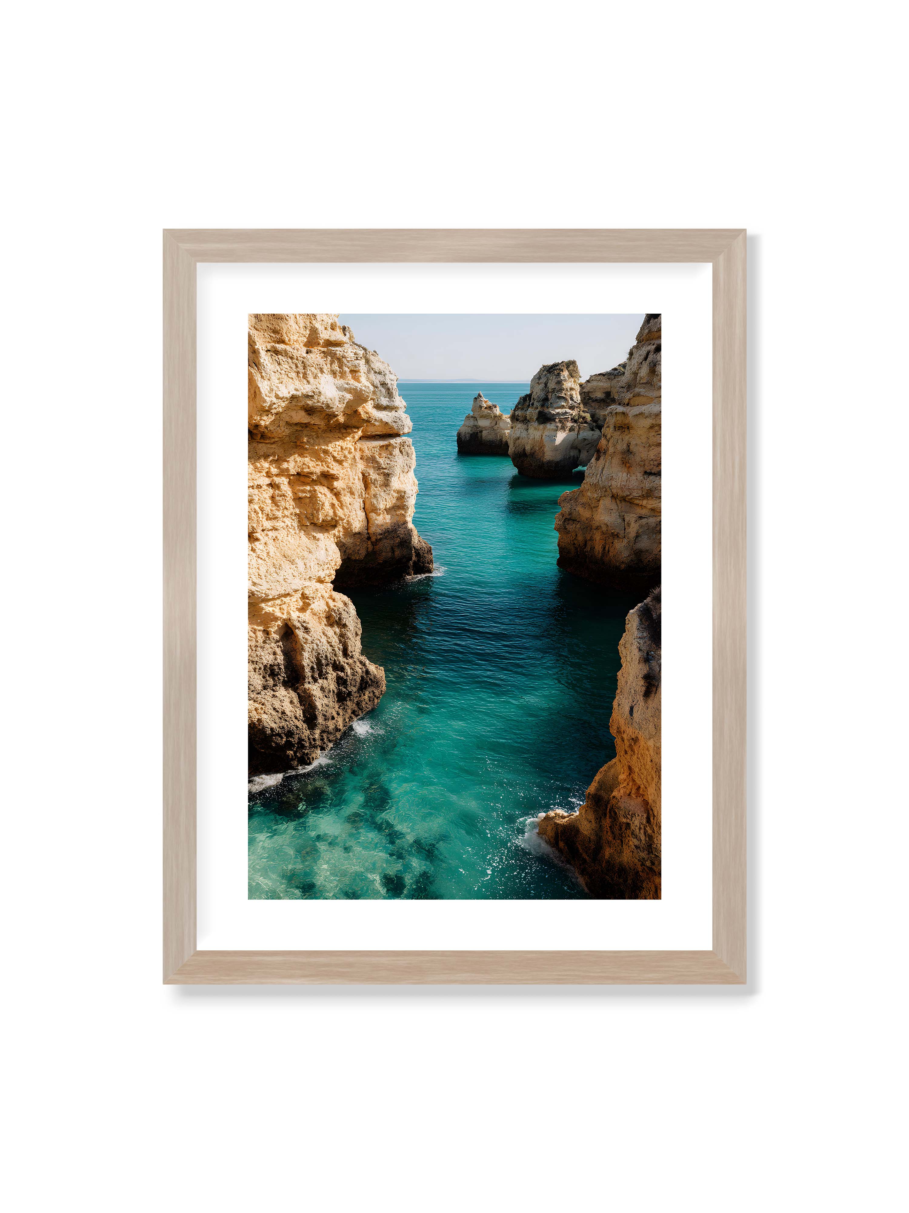 30x40 cm mit weißem Galerie-Rand im Eichenrahmen – Felsen an einer Küste, umgeben von klarem, türkisfarbenem Wasser, das sanft an die Klippen schwappt.