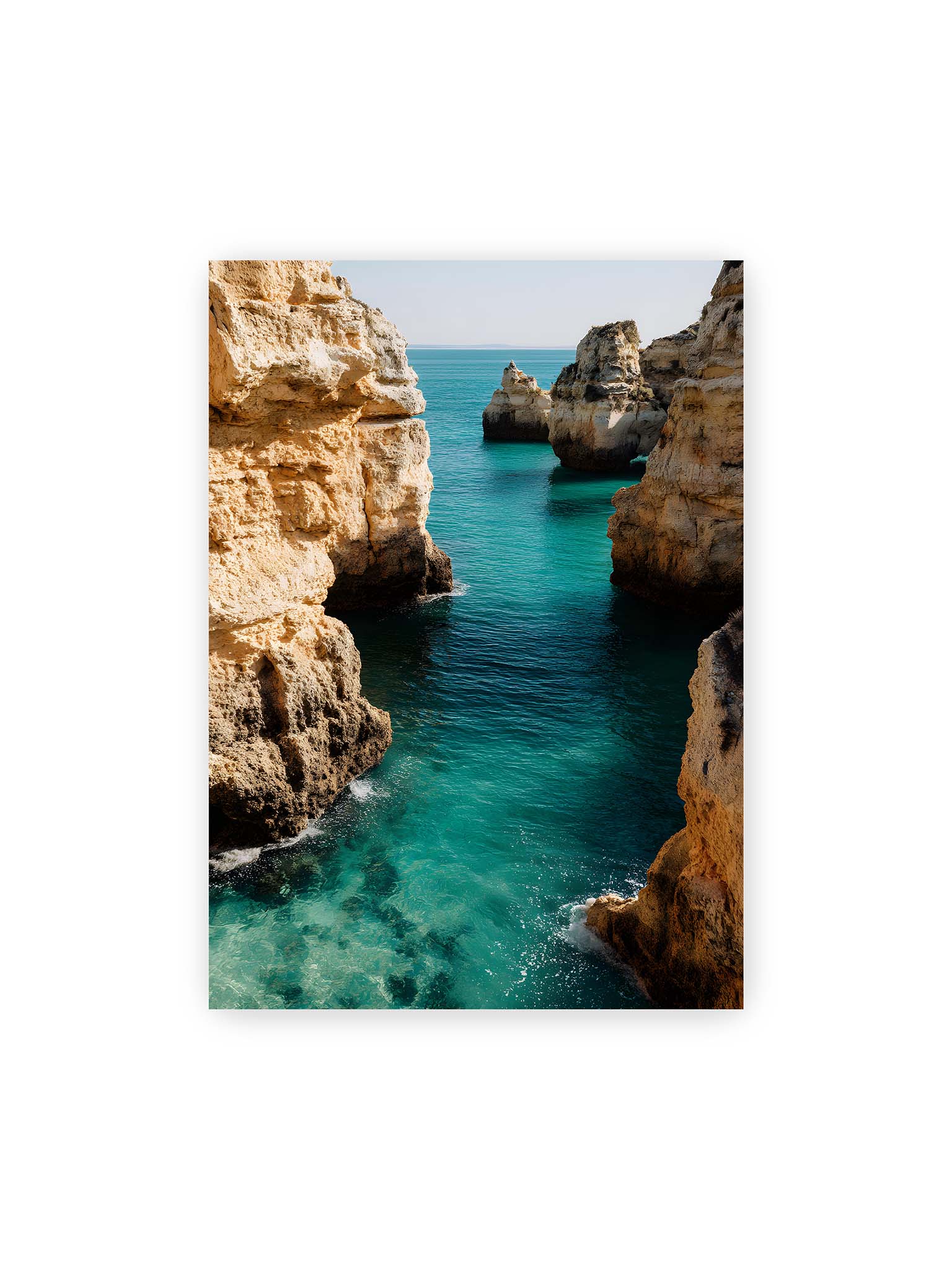 50x70 cm – Mehrere Felsen an einer Küste der Algarve, umgeben von klarem, türkisfarbenem Wasser, das sanft an die Klippen schwappt.