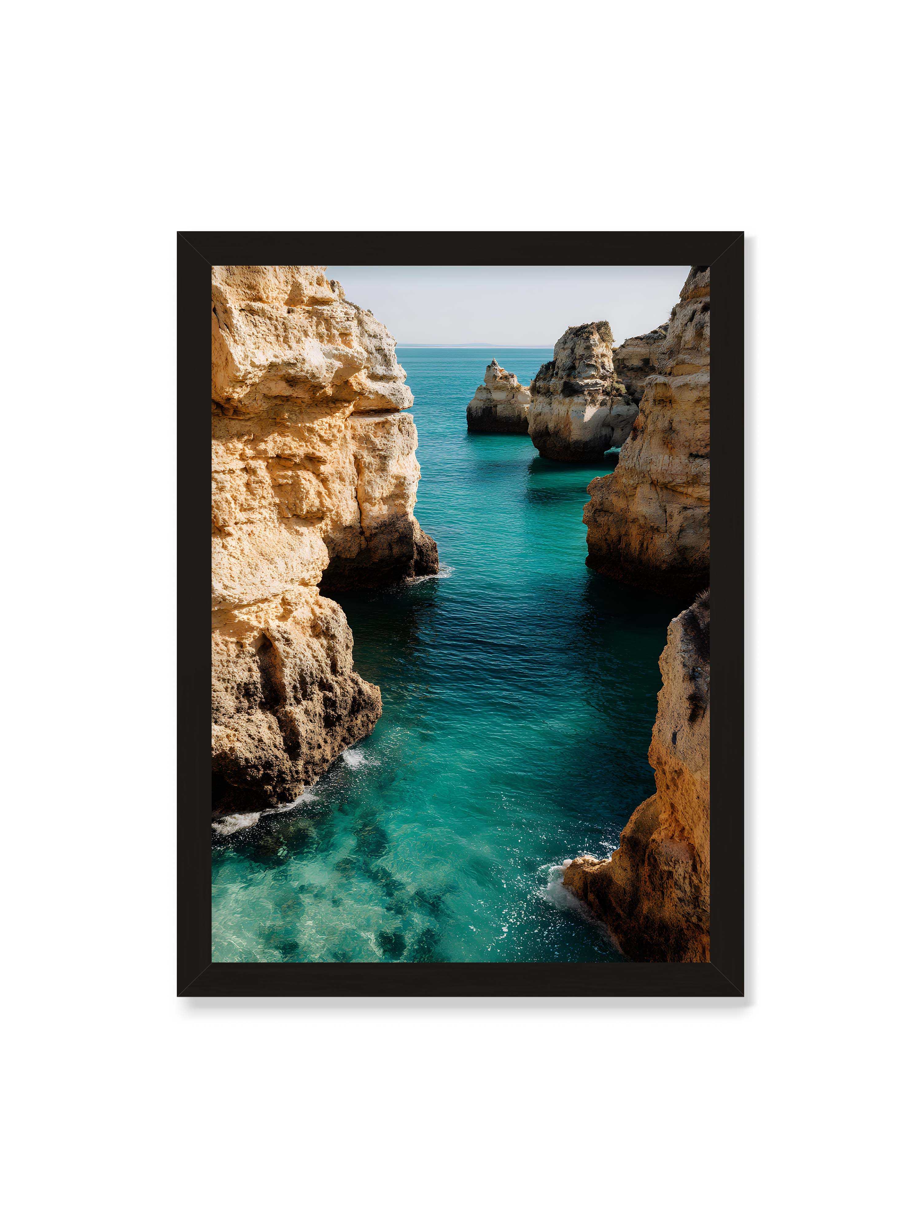 50x70 cm ohne Galerie-Rand mit schwarzem Rahmen – Felsen an einer Küste, umgeben von klarem, türkisfarbenem Wasser, das sanft an die Klippen schwappt.