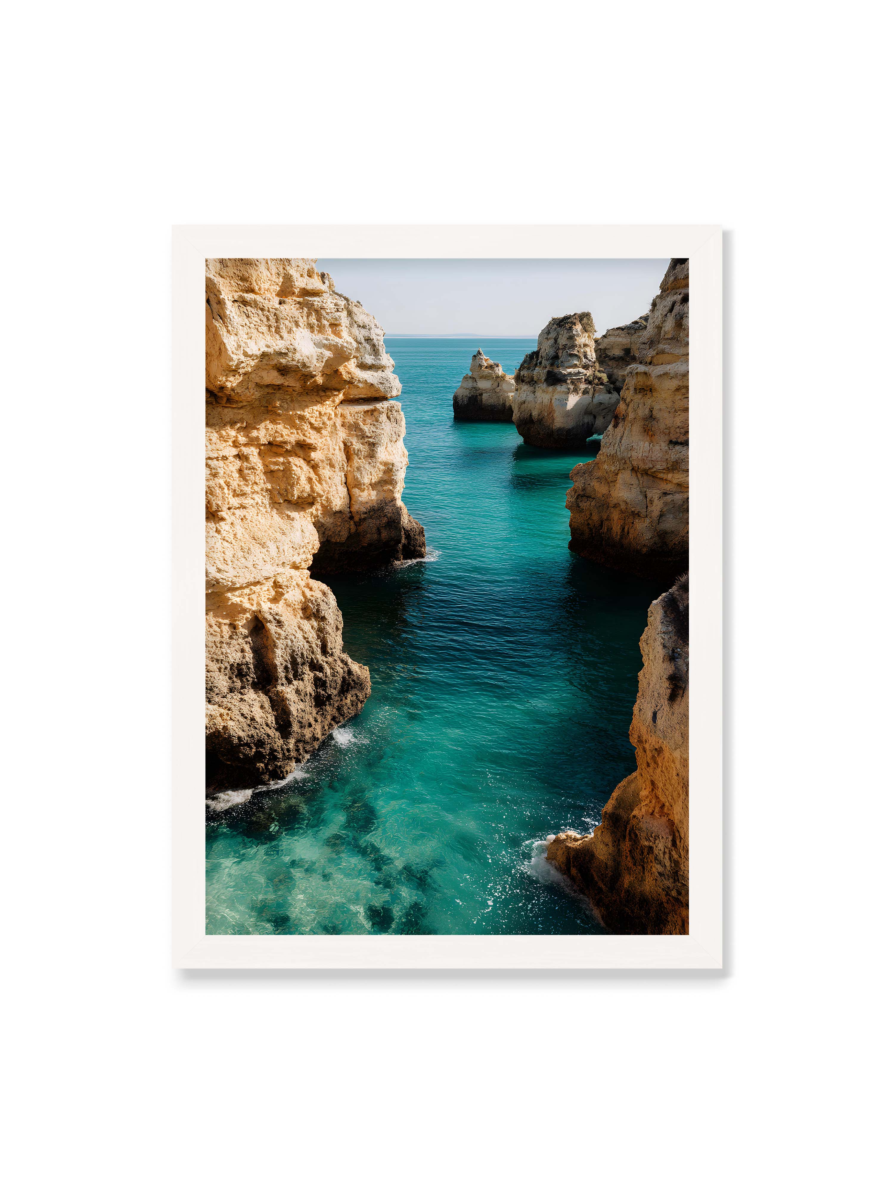 50x70 cm ohne Galerie-Rand mit weißem Rahmen – Felsen an einer Küste, umgeben von klarem, türkisfarbenem Wasser, das sanft an die Klippen schwappt.