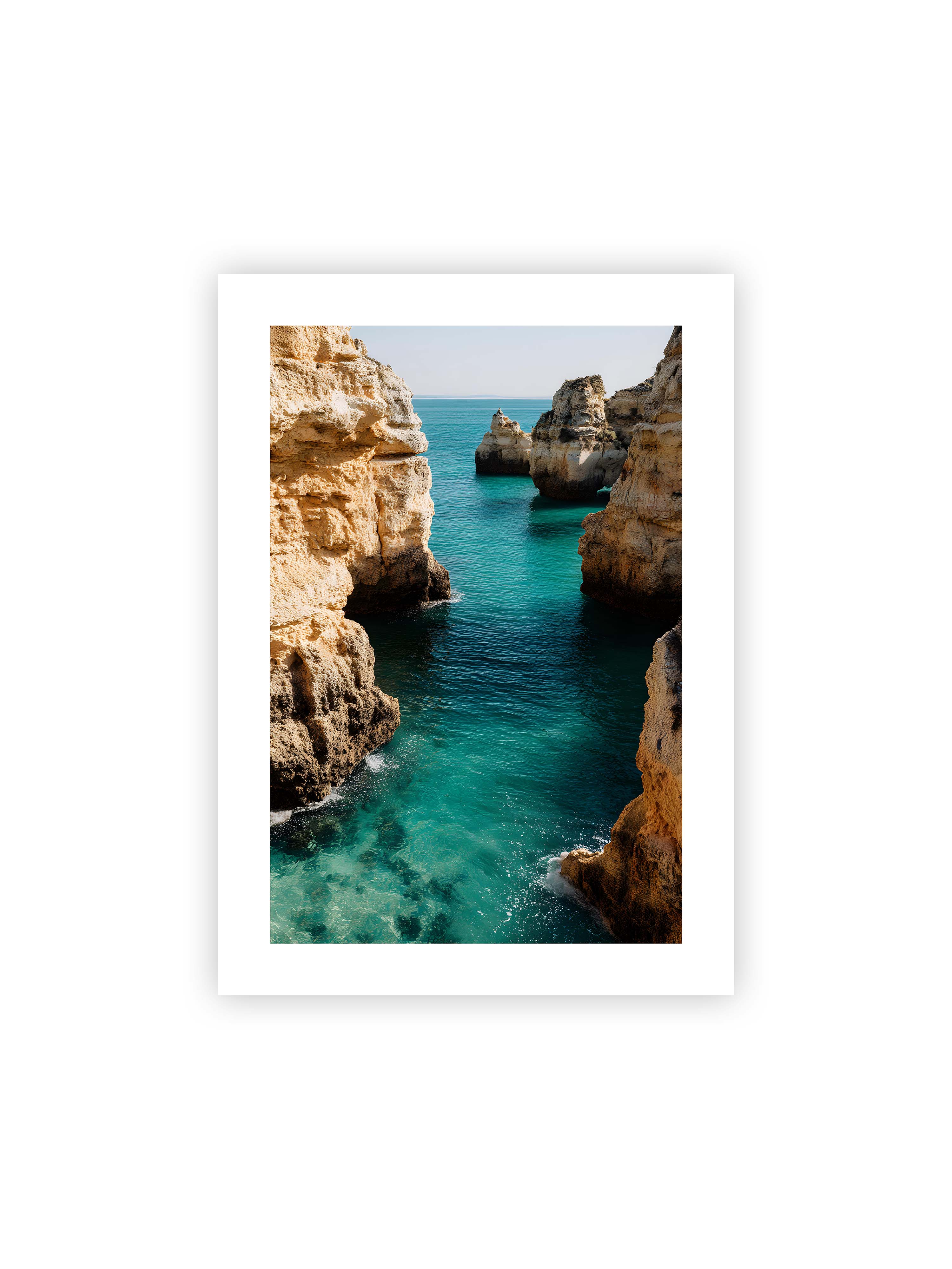 50x70 cm mit weißem Galerie-Rand ohne Rahmen – Felsen an einer Küste, umgeben von klarem, türkisfarbenem Wasser, das sanft an die Klippen schwappt.