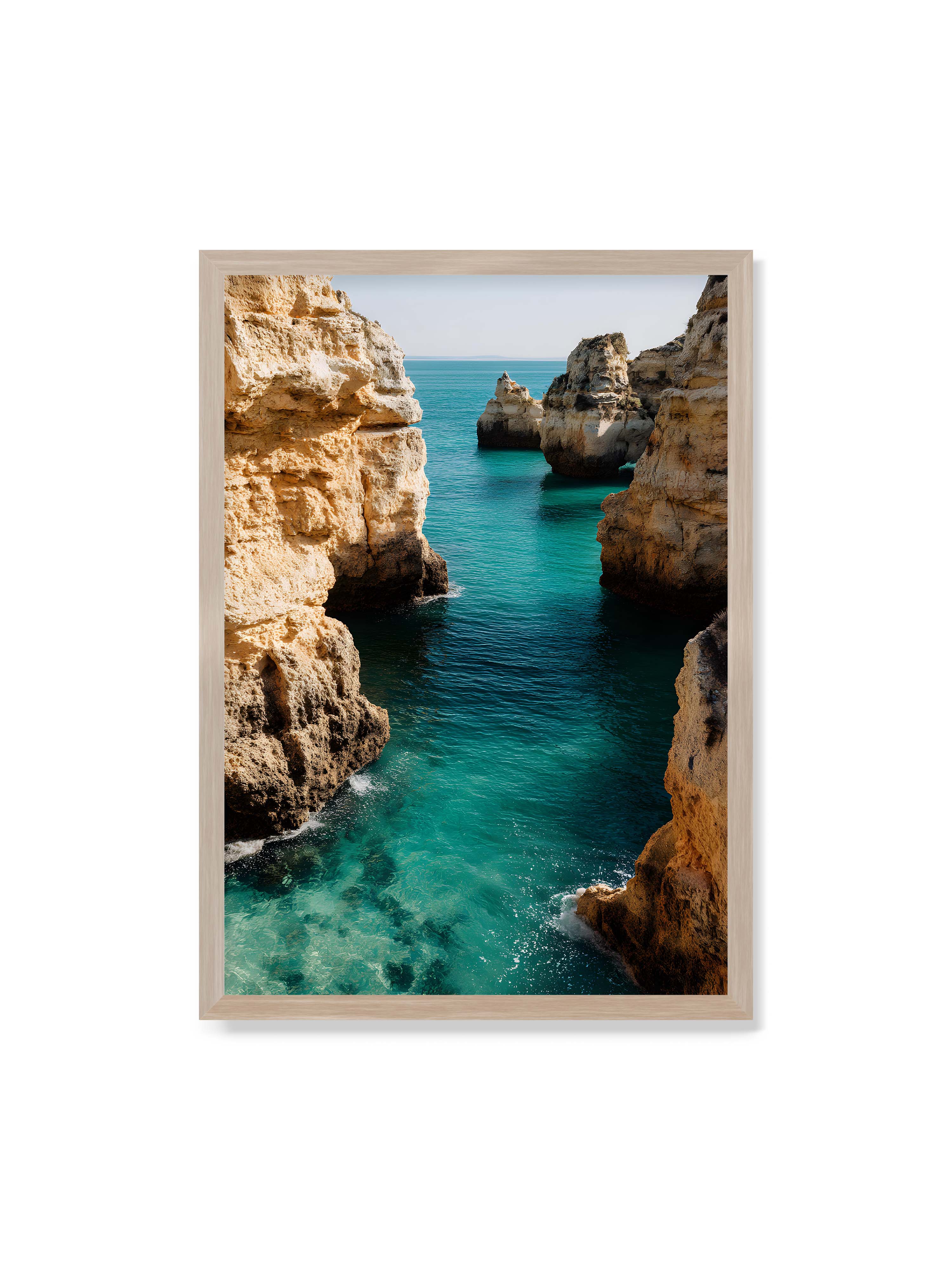 70x100 cm ohne Galerie-Rand im Eichenrahmen – Felsen an einer Küste, umgeben von klarem, türkisfarbenem Wasser, das sanft an die Klippen schwappt.