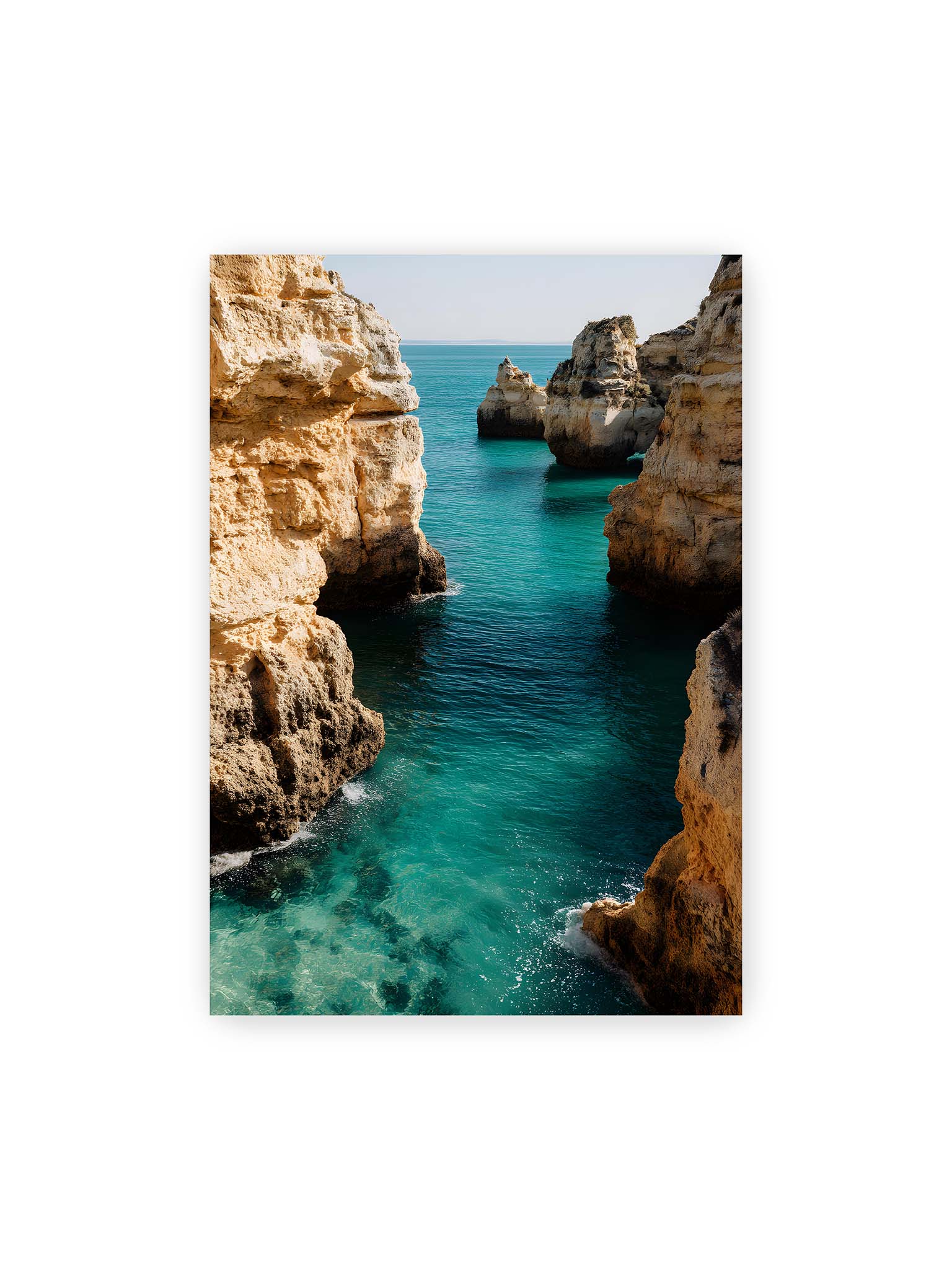 70x100 cm – Mehrere Felsen an einer Küste der Algarve, umgeben von klarem, türkisfarbenem Wasser, das sanft an die Klippen schwappt.