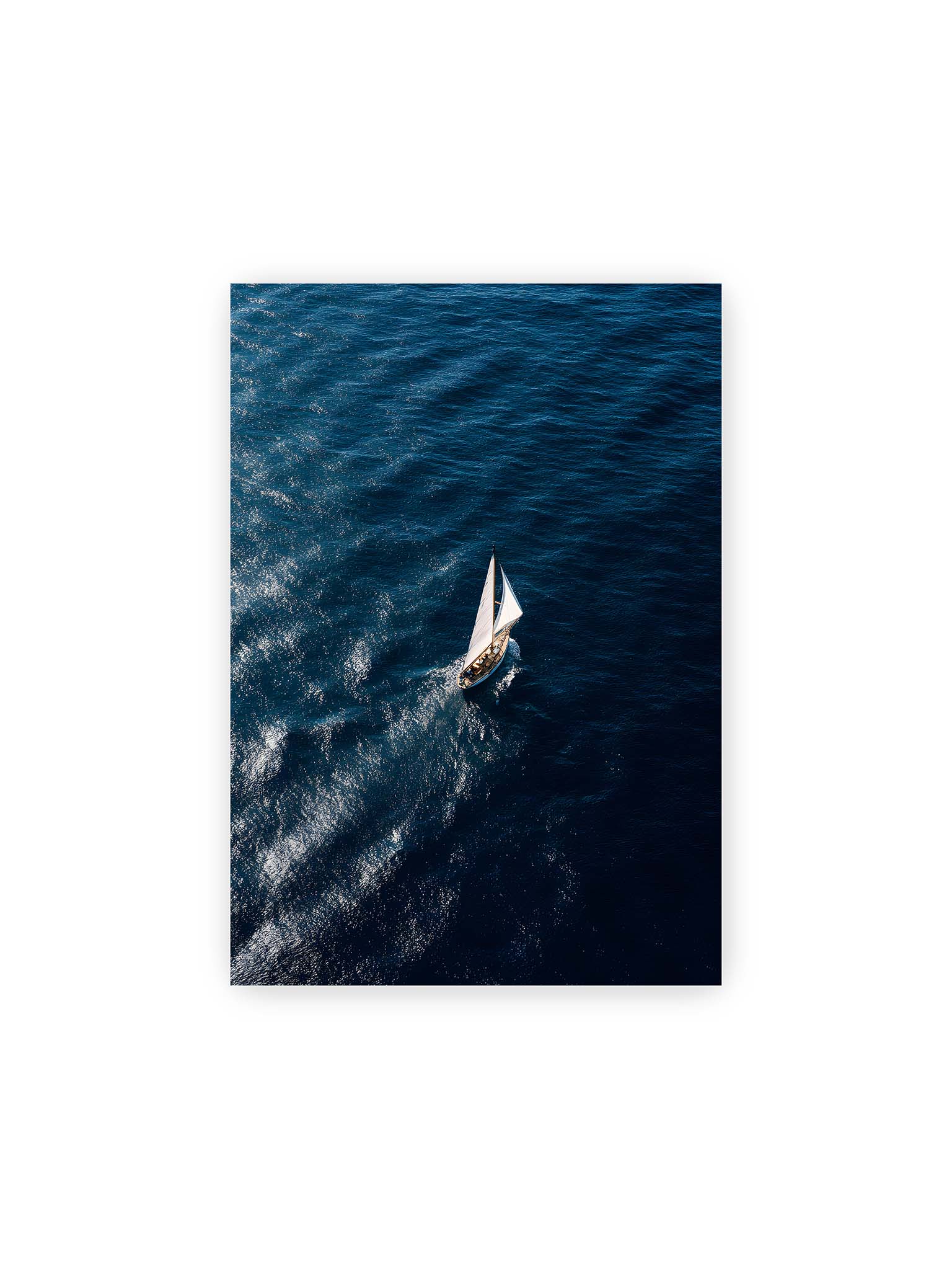 21x30 cm – Einzelnes Segelboot auf tiefblauem Meer mit sichtbaren Wasserstrukturen und sanften Spuren im Wasser.