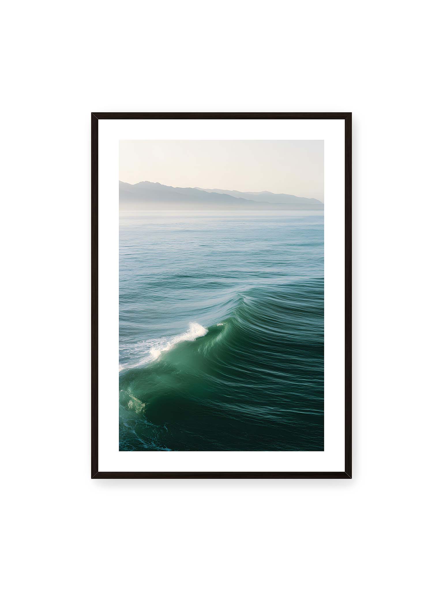 70x100 cm, weißer Galerie-Rand, schwarzer Rahmen – Sanft aufsteigende grüne Welle vor ruhigem Meer mit fernen Bergsilhouetten im Hintergrund.