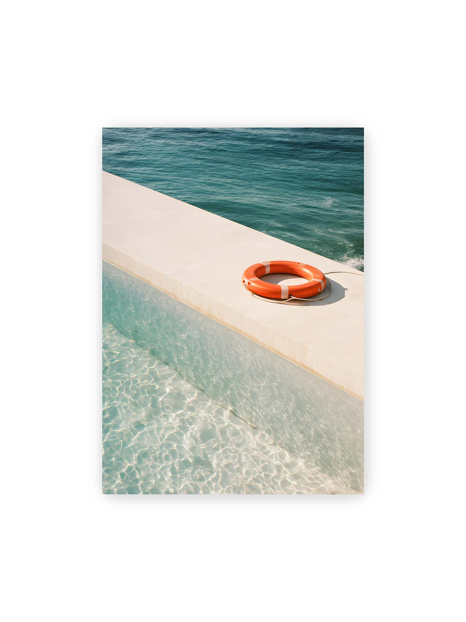 50x70 cm – Rettungsring liegt auf heller Kante zwischen Poolwasser und offenem Meer mit klarer Trennung der Flächen.