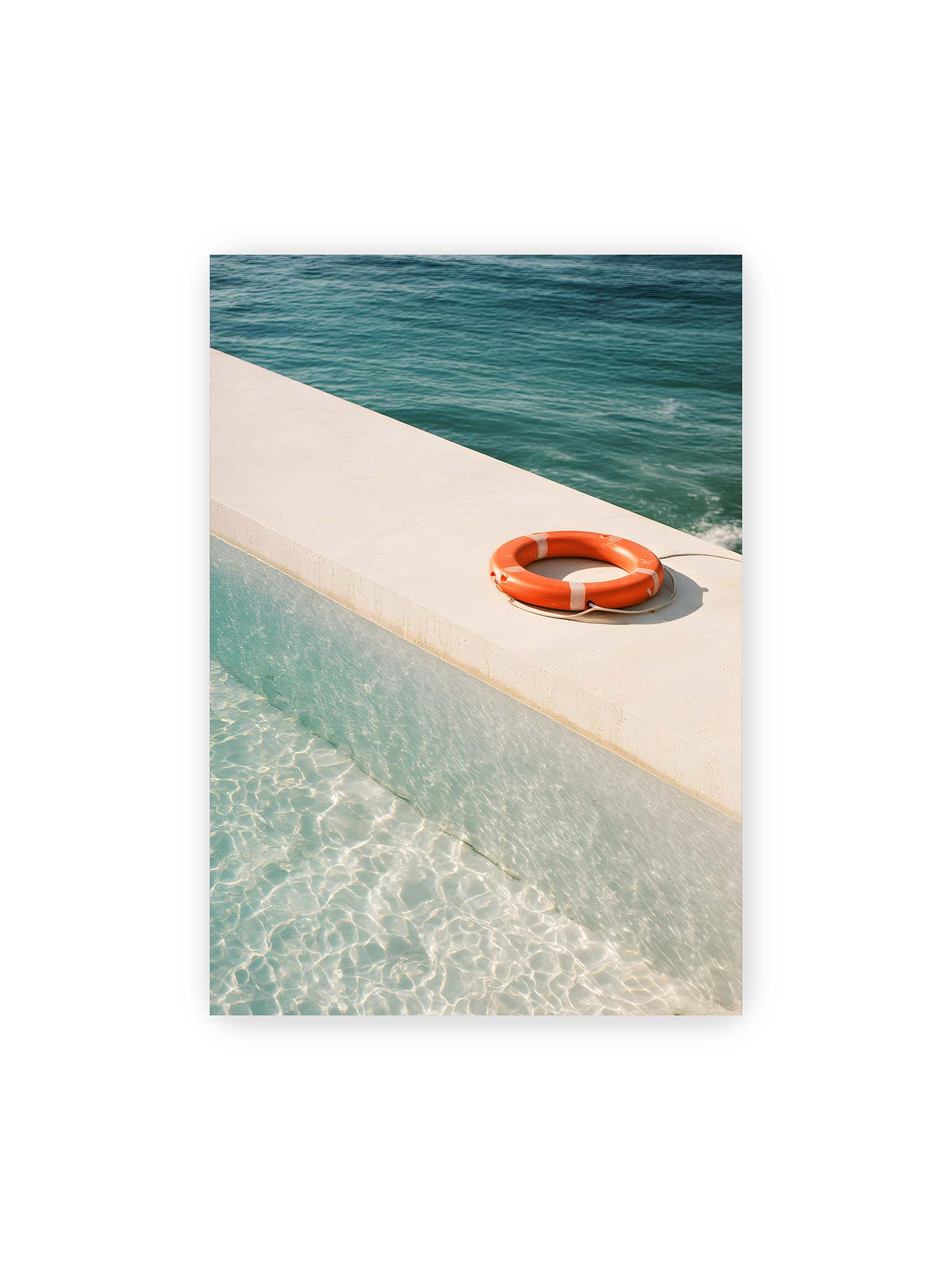 70x100 cm – Rettungsring liegt auf heller Kante zwischen Poolwasser und offenem Meer mit klarer Trennung der Flächen.