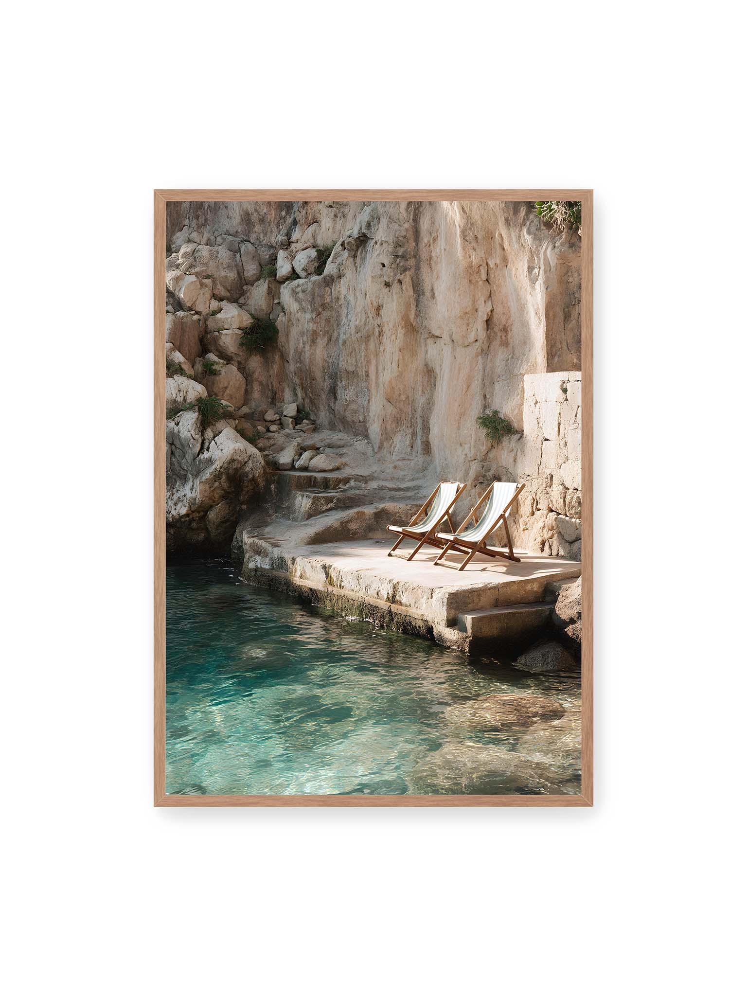 70x100 cm, Eichenrahmen – Zwei Liegestühle auf Felsplattform am klaren Wasser, umgeben von rauer Küstenwand und sanftem Licht.