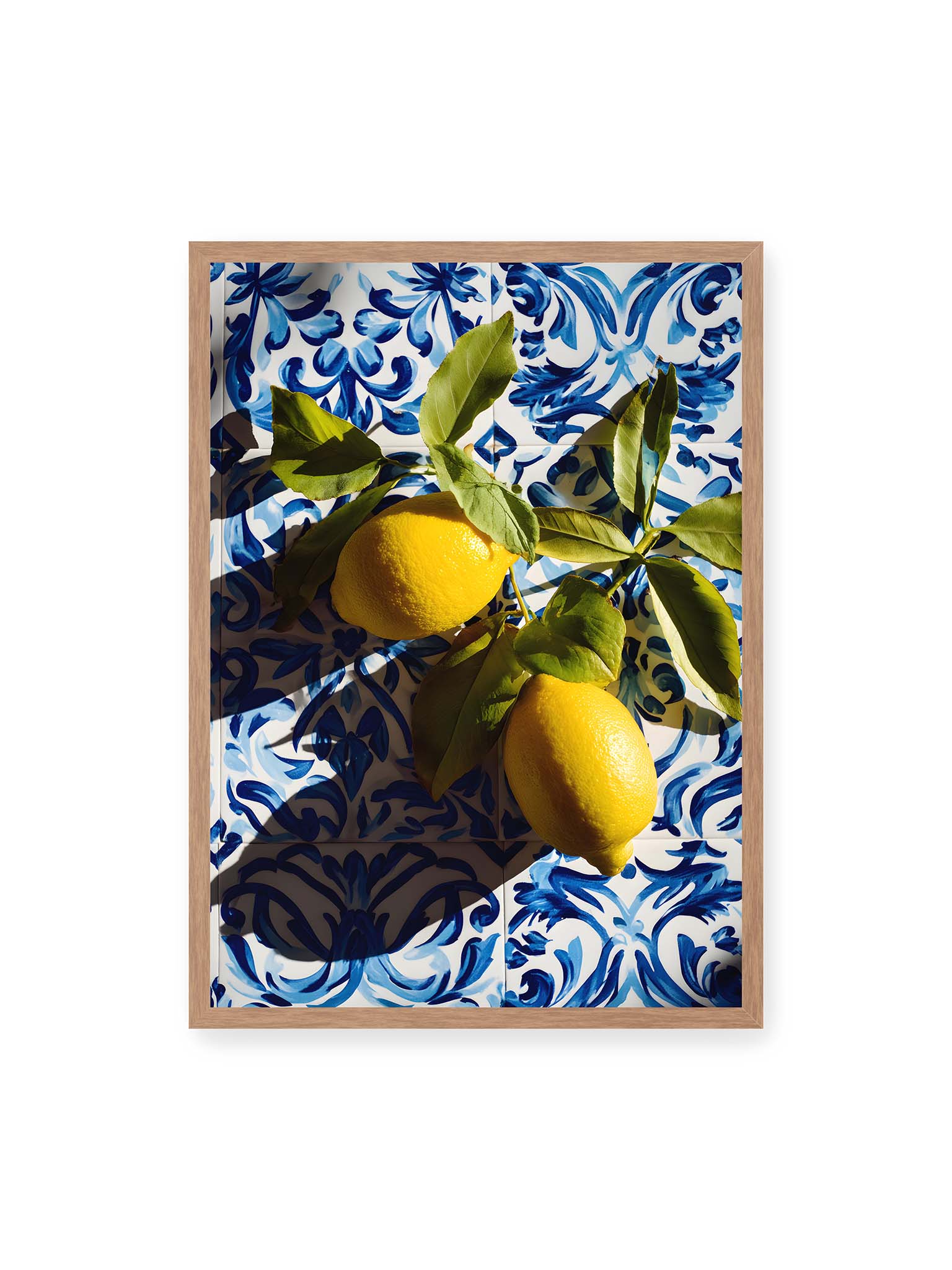 50x70 cm, Eichenrahmen – Zitronen mit Blättern auf blau gemusterten Fliesen mit starkem Licht und klaren Schatten.