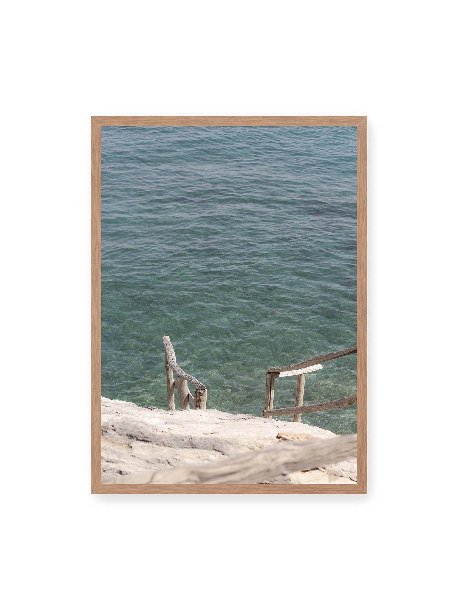 50x70 cm, Eichenrahmen – Holztreppe führt über helle Felsen in klares, ruhiges Meer mit sichtbarer Wasserstruktur.