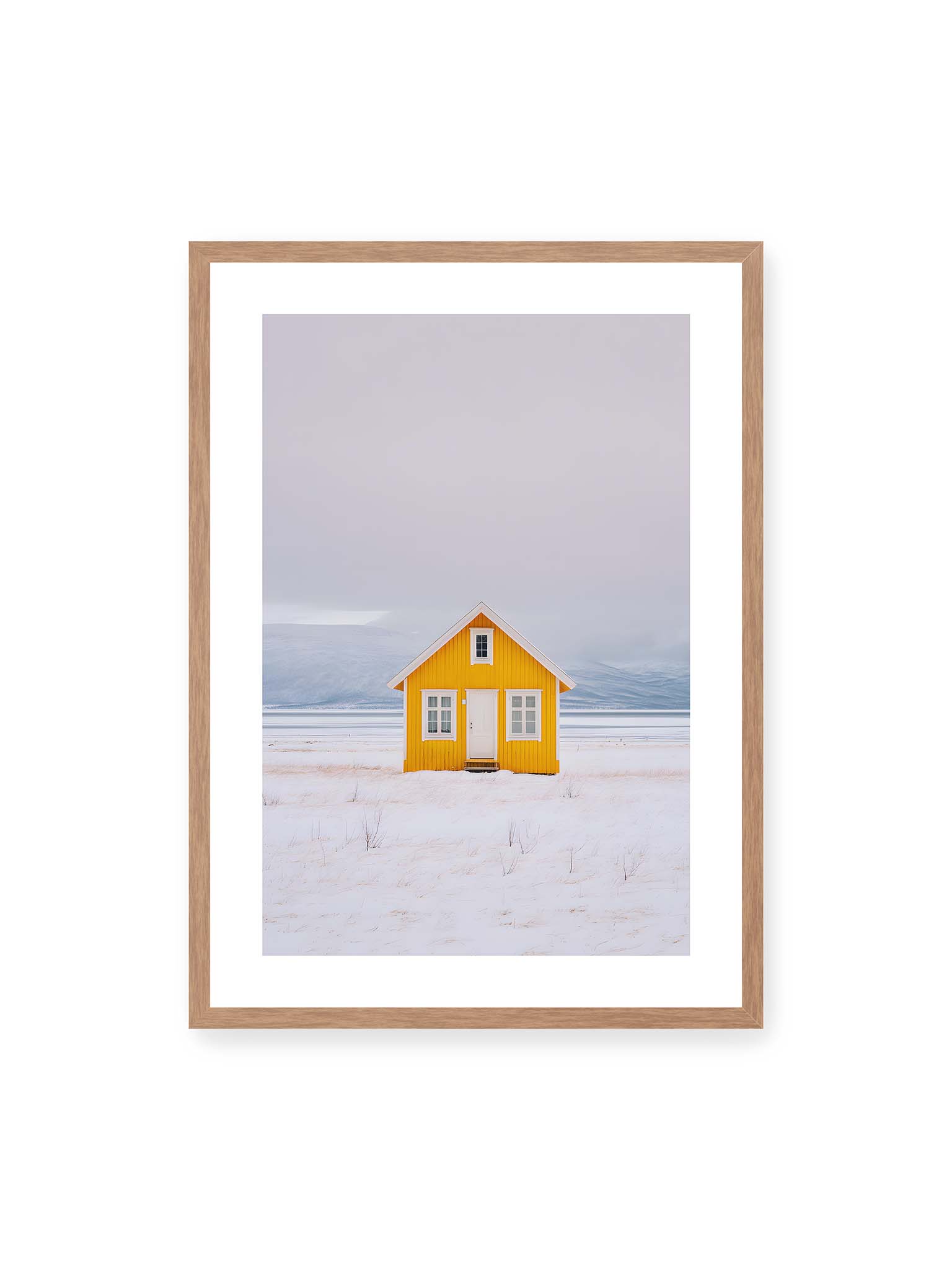 50x70 cm, weißer Galerie-Rand, Eichenrahmen – Gelbes Haus steht allein in weiter verschneiter Landschaft mit Bergen im Hintergrund und grauem Himmel.